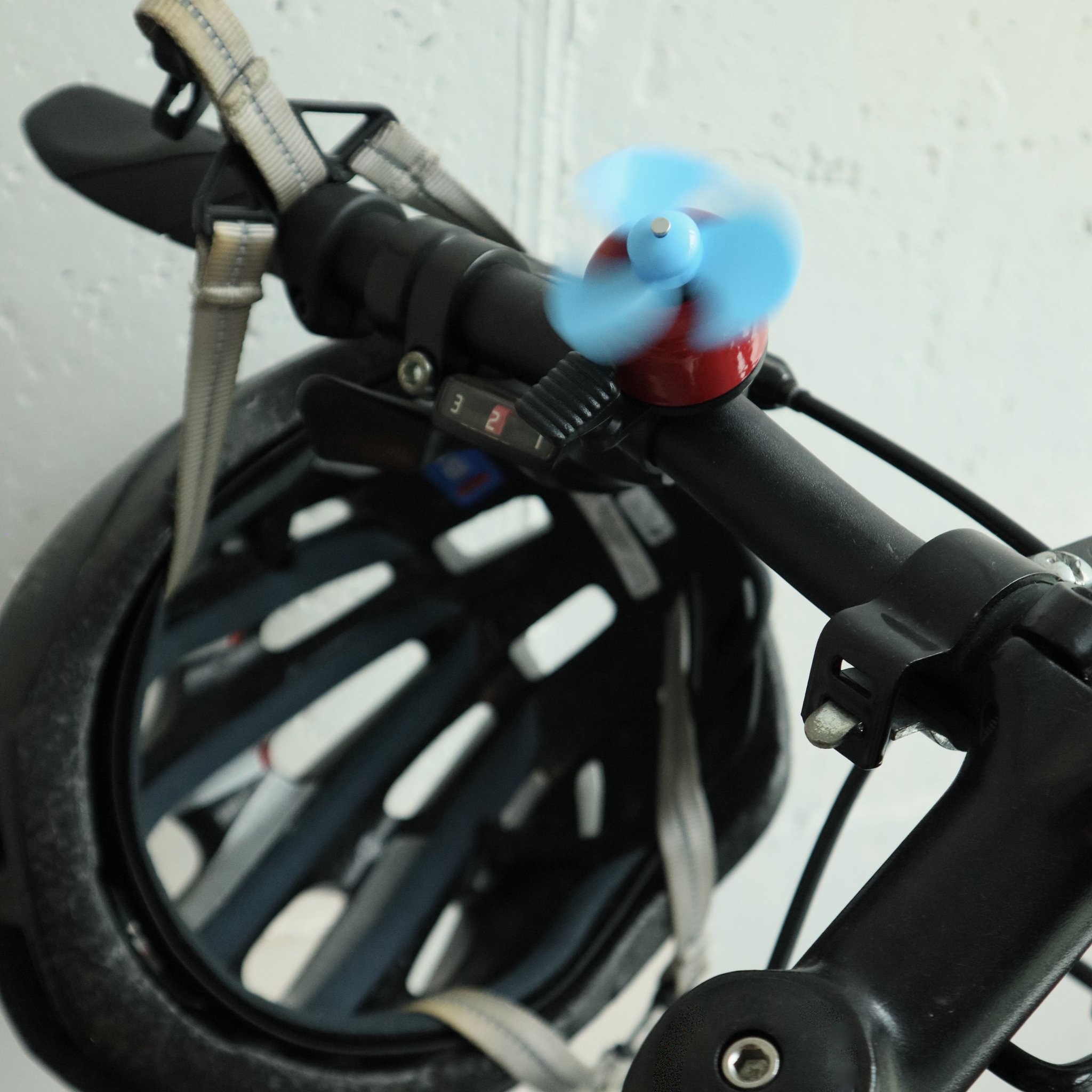 Campanello da bici blu con mulino a vento montato sul manubrio