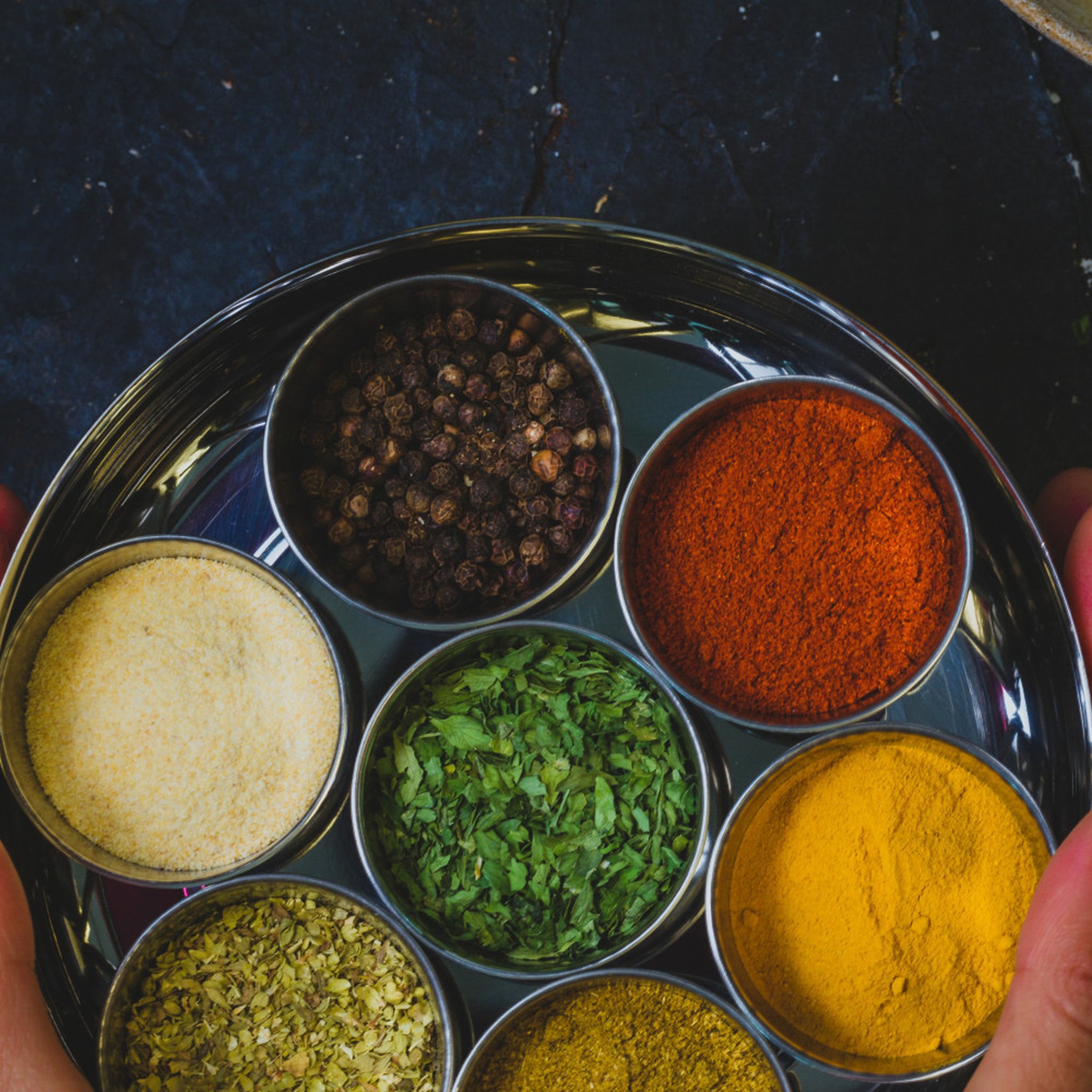 Masala Dabba Draufsicht mit 7 bunten Gewürzen in Edelstahltöpfen