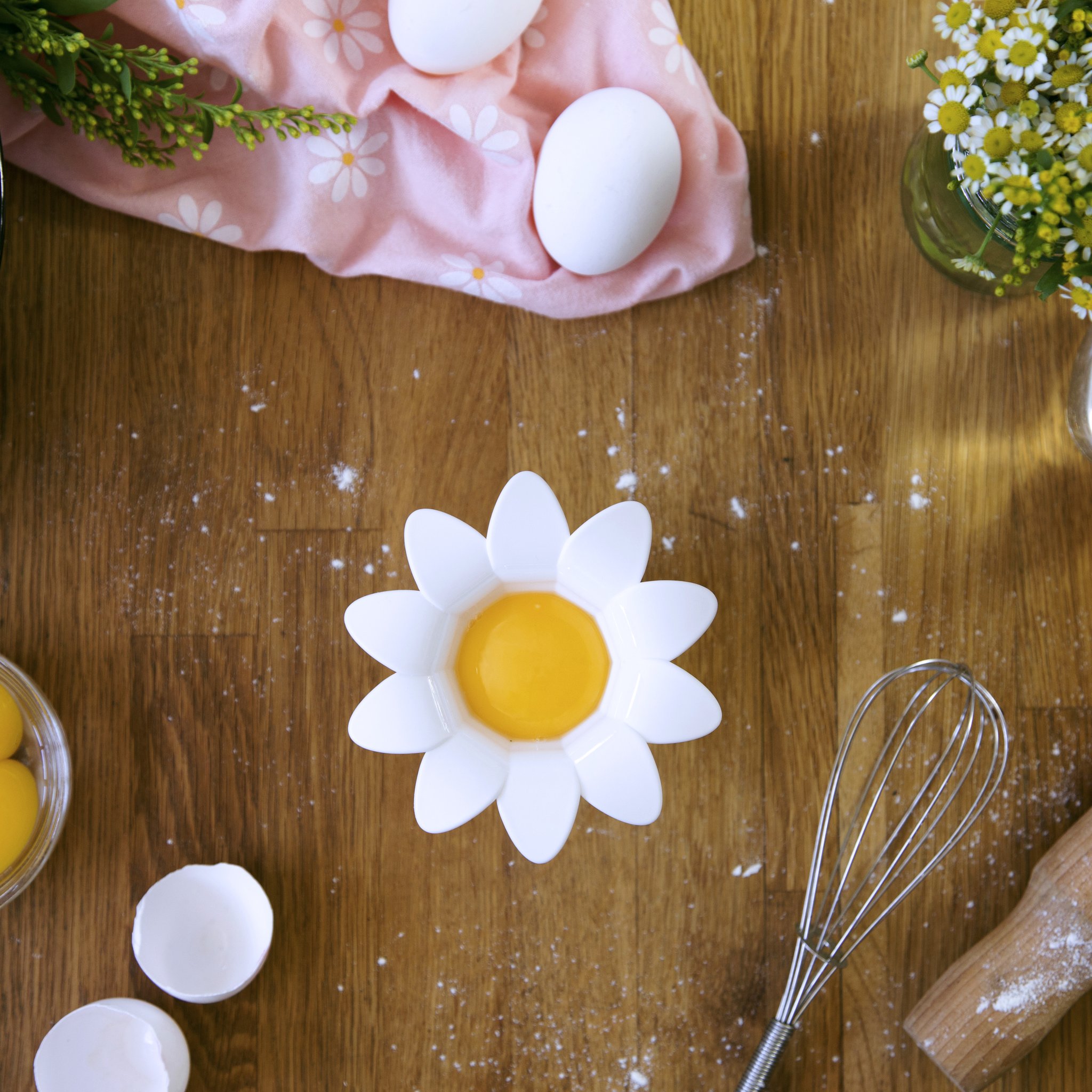 Gänseblümchen Eitrenner mit Eigelb auf einem Holztisch mit Backzutaten