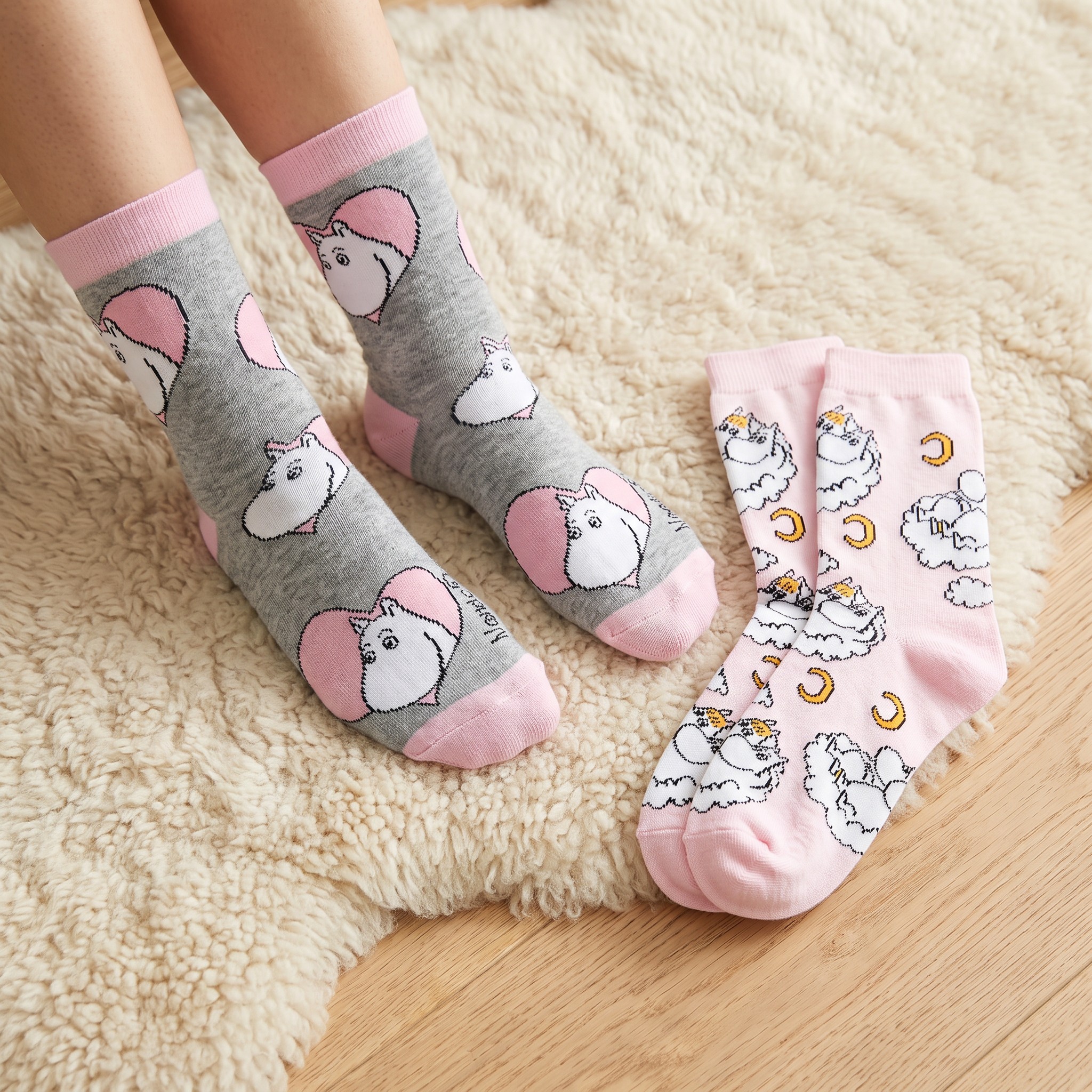 Calze Moomin grigie indossate su un tappeto, con il secondo paio accanto
