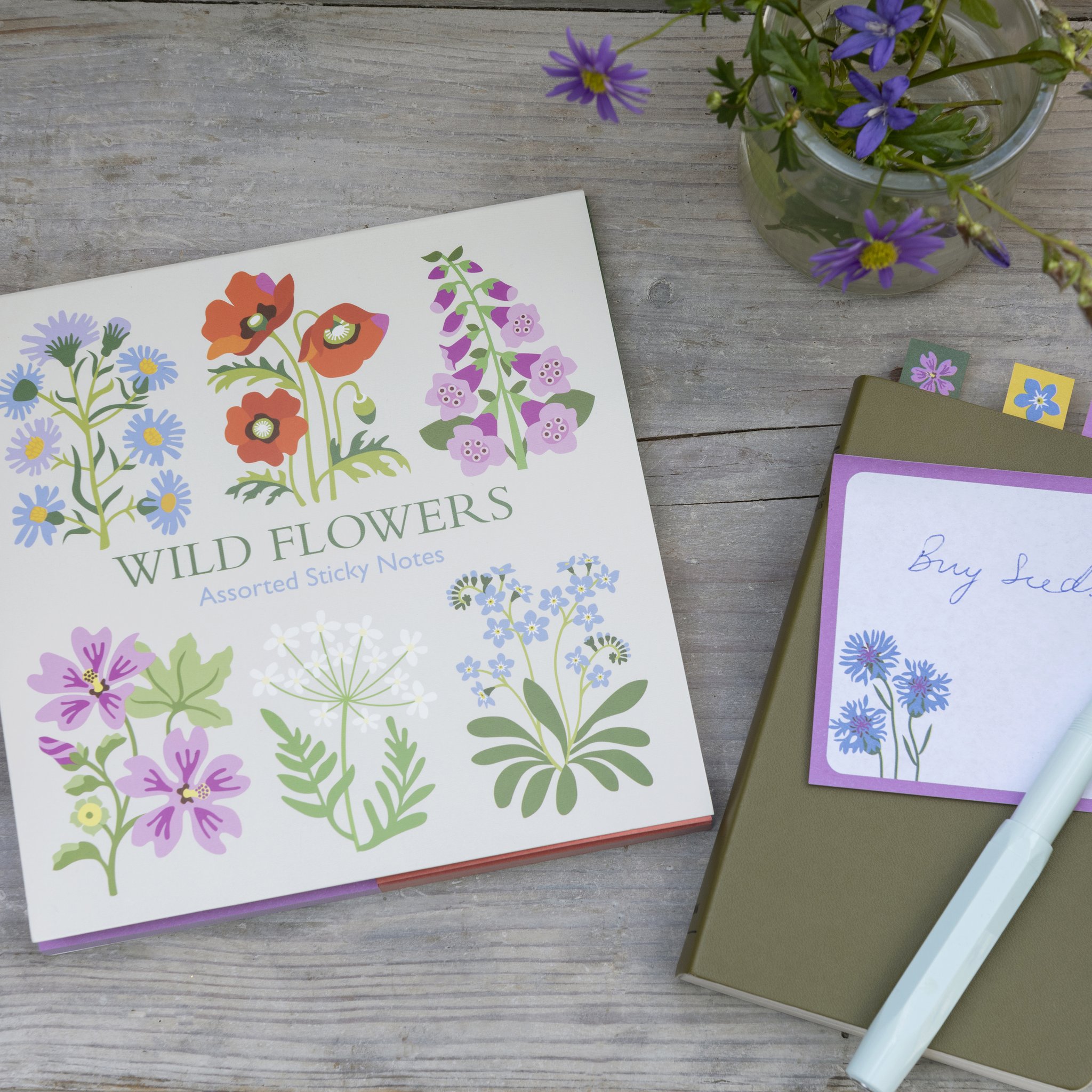 Notes adhésives fleurs sauvages : bloc à motif floral à côté d'un carnet, d'un stylo et d'un bouquet