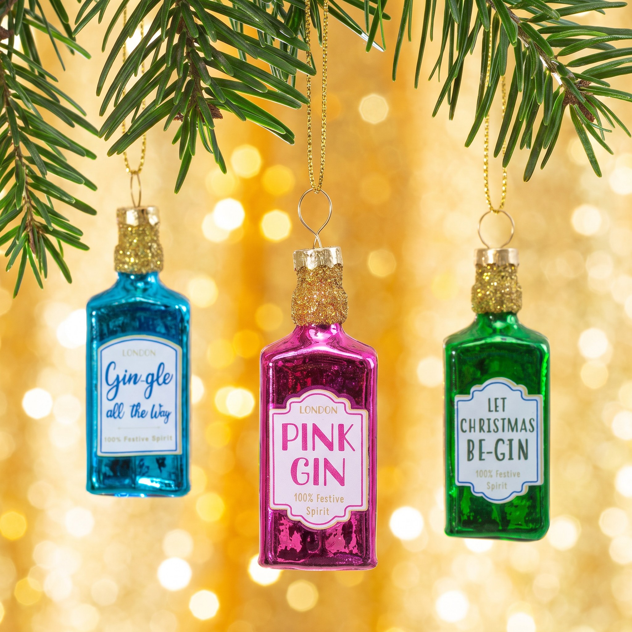 Mini Gin Bottles Bauble Set by Sass & Belle on a fir branch against golden glitter