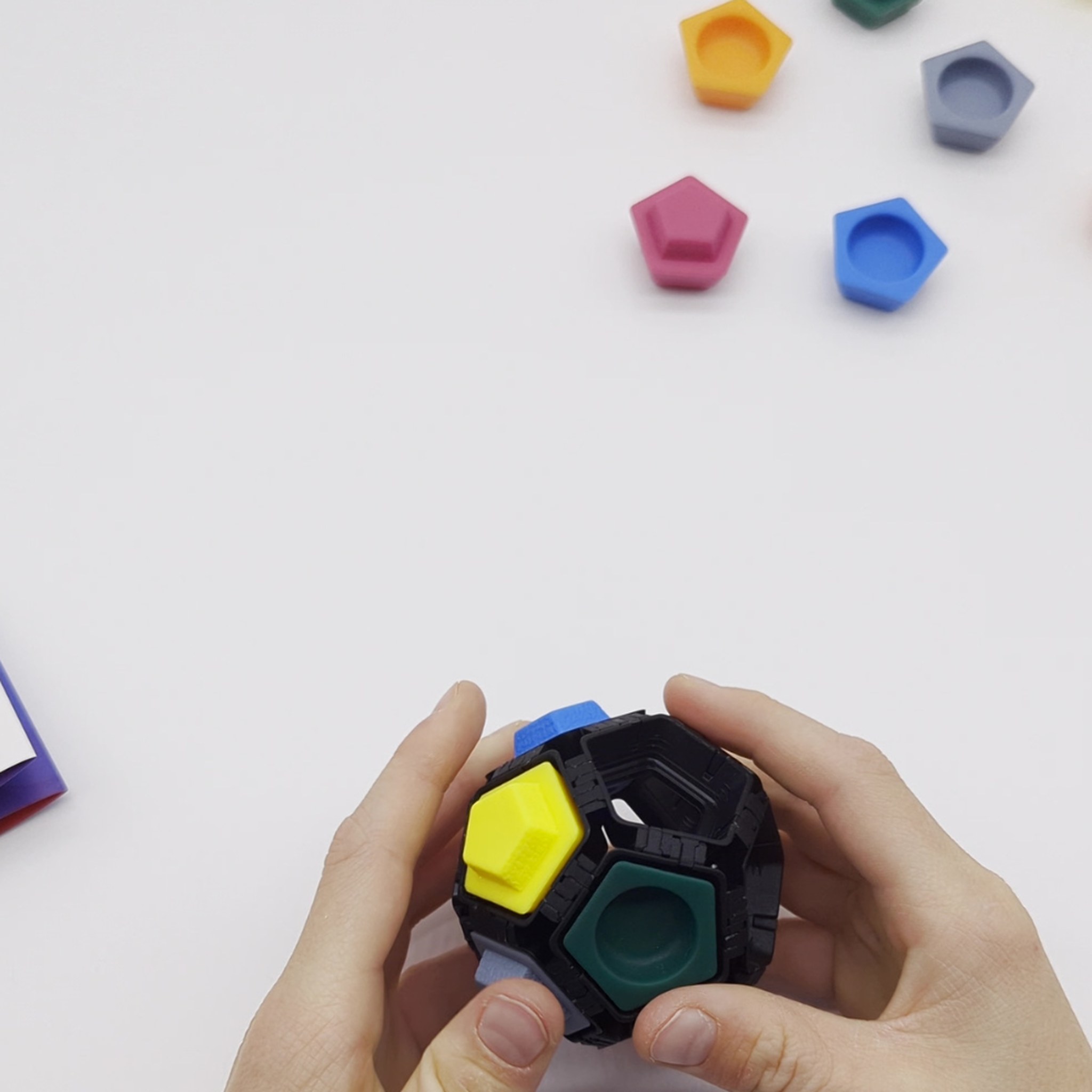 Mani che inseriscono le prese colorate nella pallina Pocket Ninja