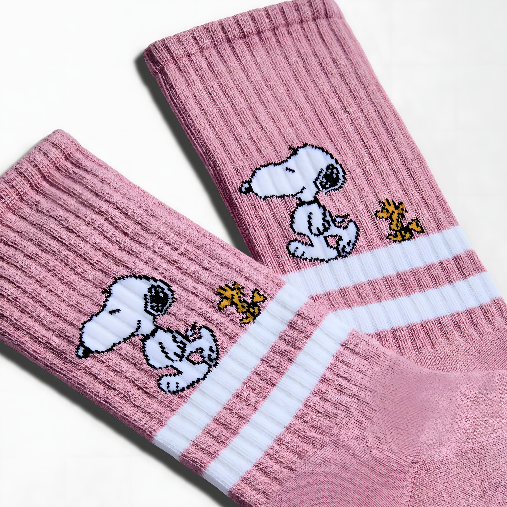 Close-up of the pink Snoopy tennis socks: Snoopy and Woodstock above the white stripes