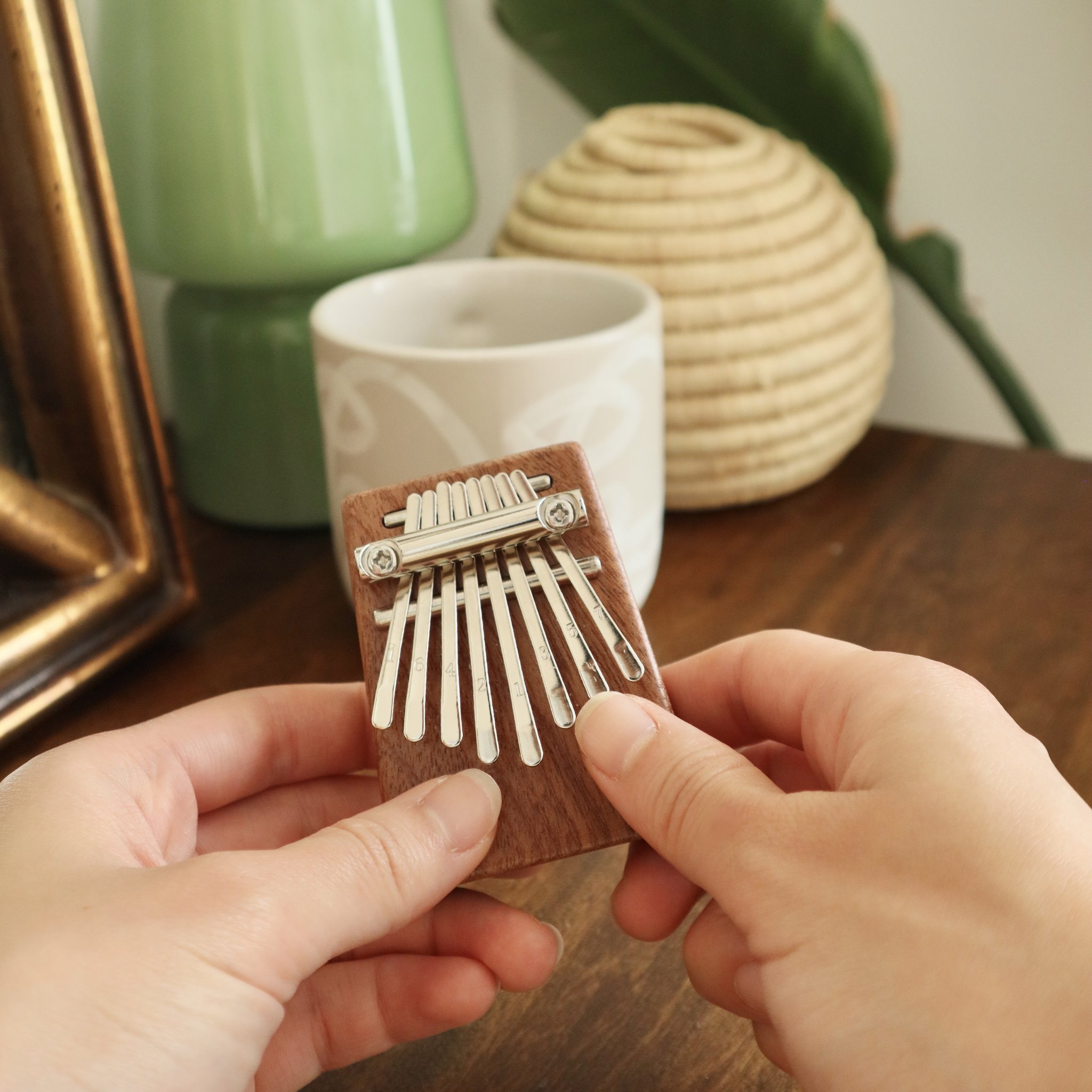 Hände spielen die kleine Kalimba aus Holz