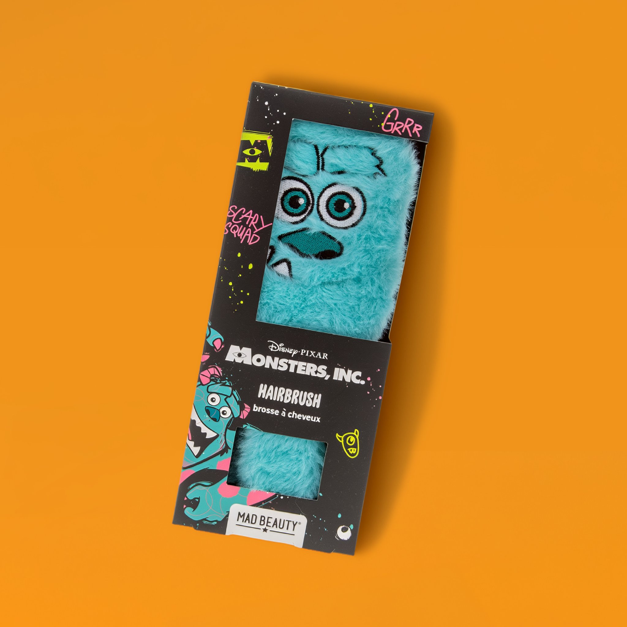 Spazzola districante Monsters & Co. con peluche Sulley turchese nella confezione, sfondo arancione