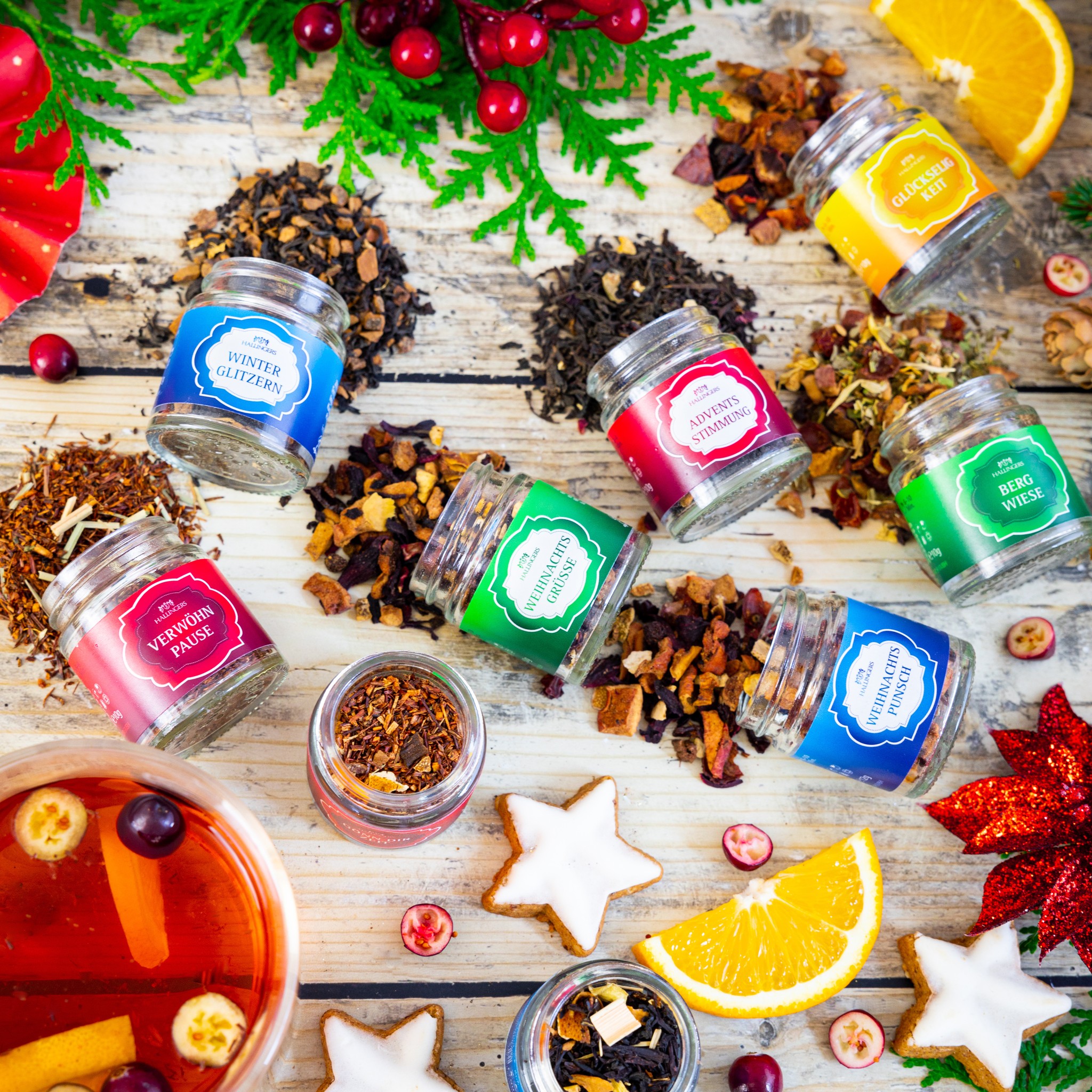 Teegläser aus dem Tee-Adventskalender Christmas Car mit losem Tee, Zimtsternen, Orangen und Cranberries auf Holz
