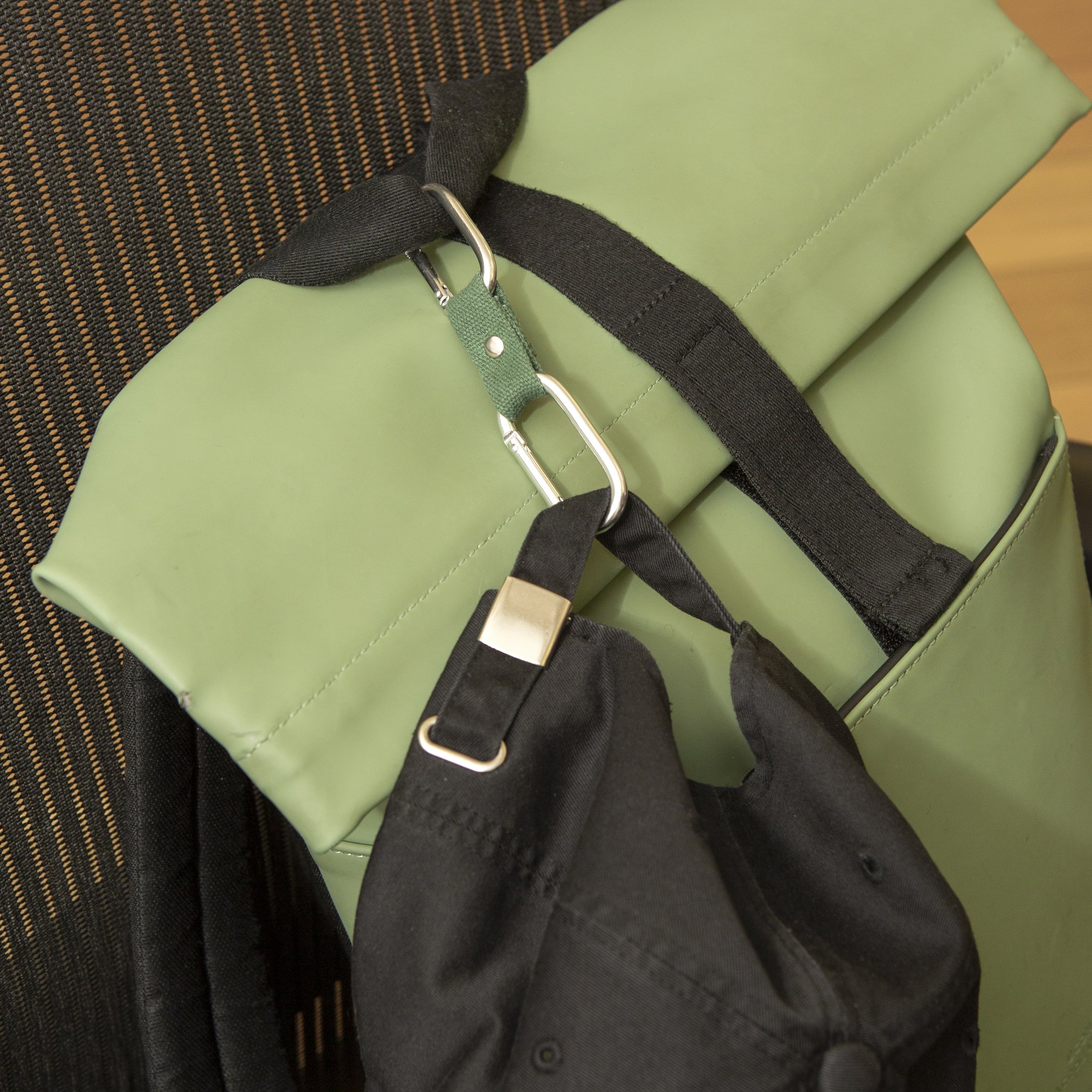 Dual Clip Buddy che aggancia una borsa nera alla tracolla di una borsa verde