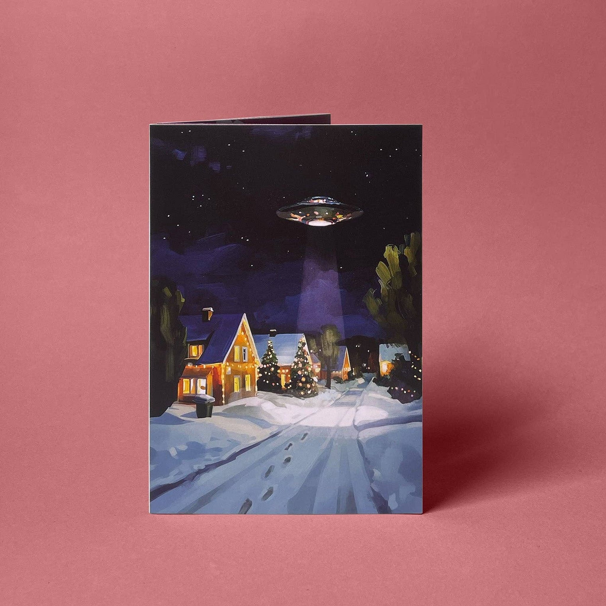 Vorderseite der Weihnachtskarte mit UFO über verschneitem Dorf zum Selberfalten