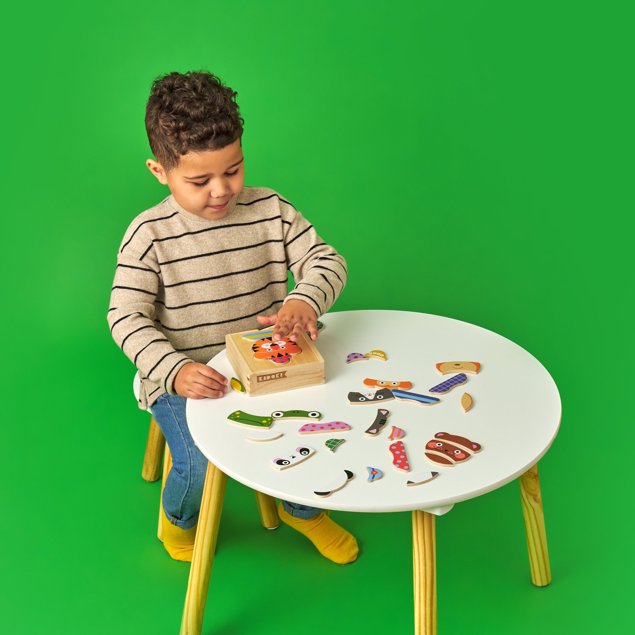 Garçon regardant la boîte en bois du puzzle animaux