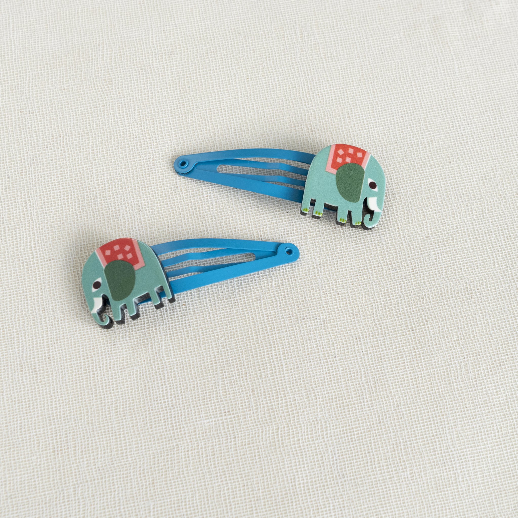 Les deux barrettes éléphant bleues sur du lin
