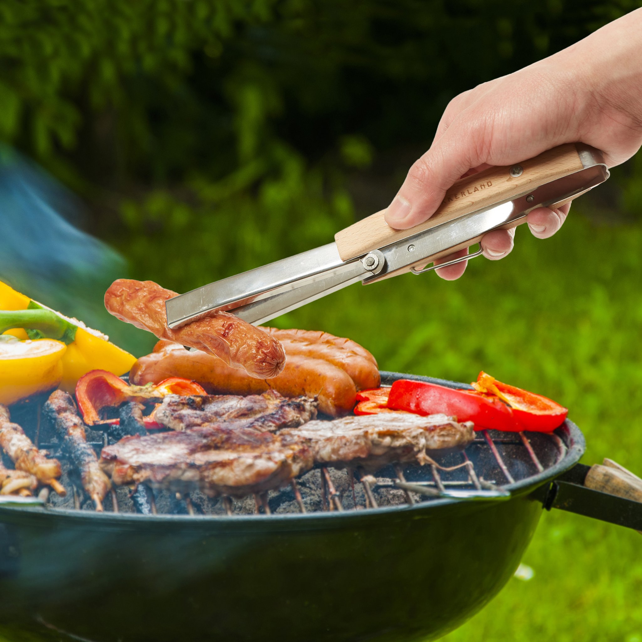 Pince à grill pliable retournant des saucisses sur le barbecue