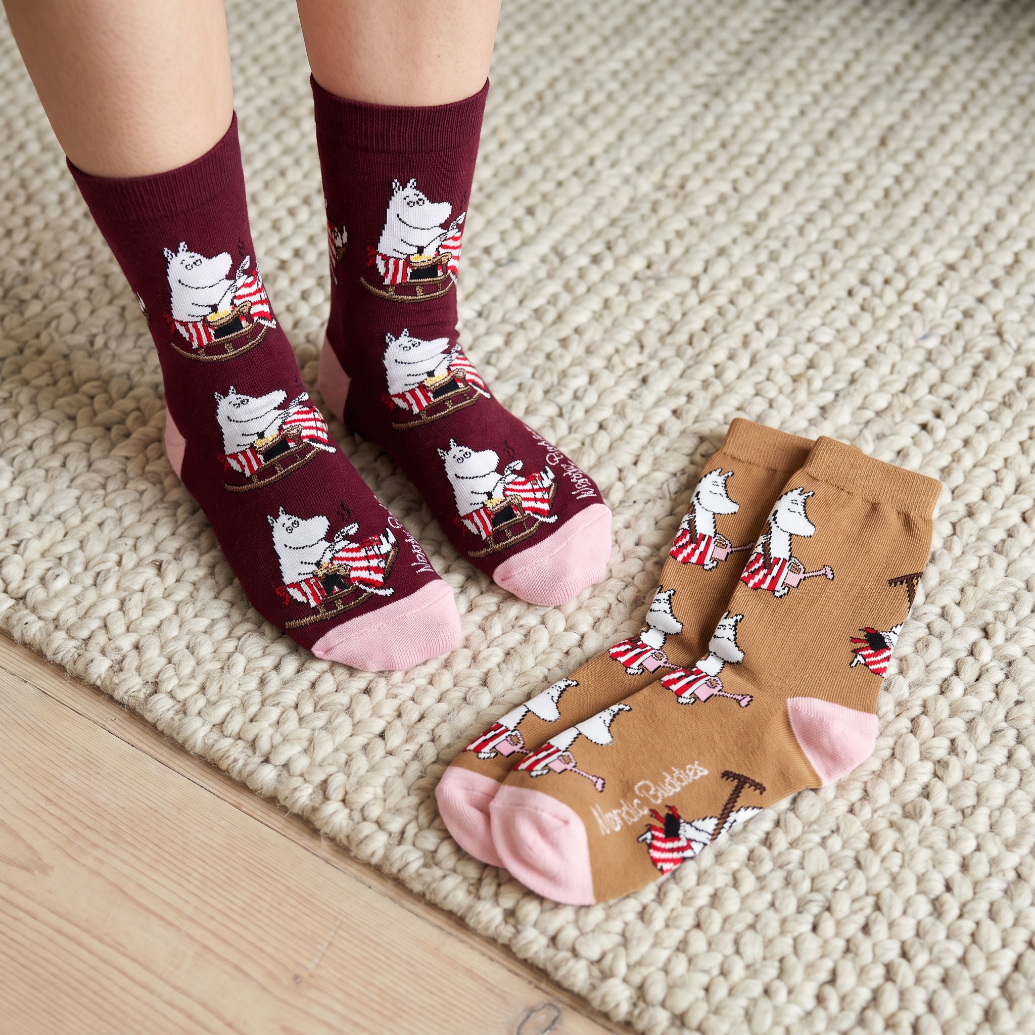 Calze Moomin bordeaux indossate su un tappeto, con il secondo paio accanto