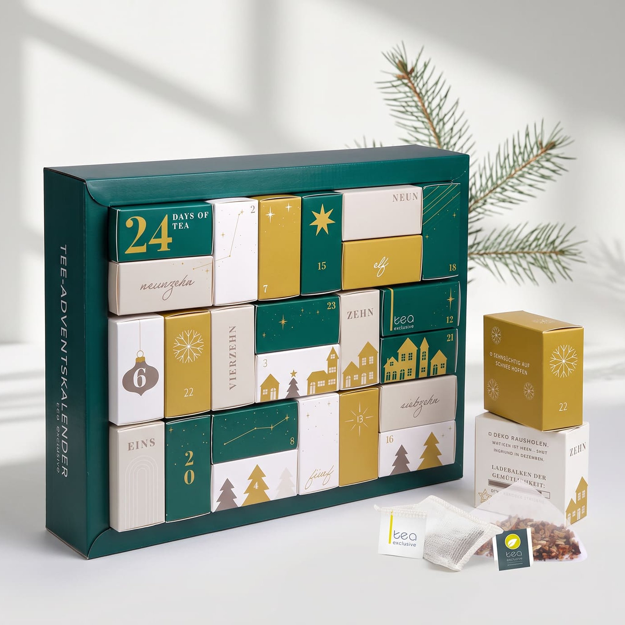Tee-Adventskalender 2026 von der Seite, daneben Tannenzweig und offene Pyramidenbeutel