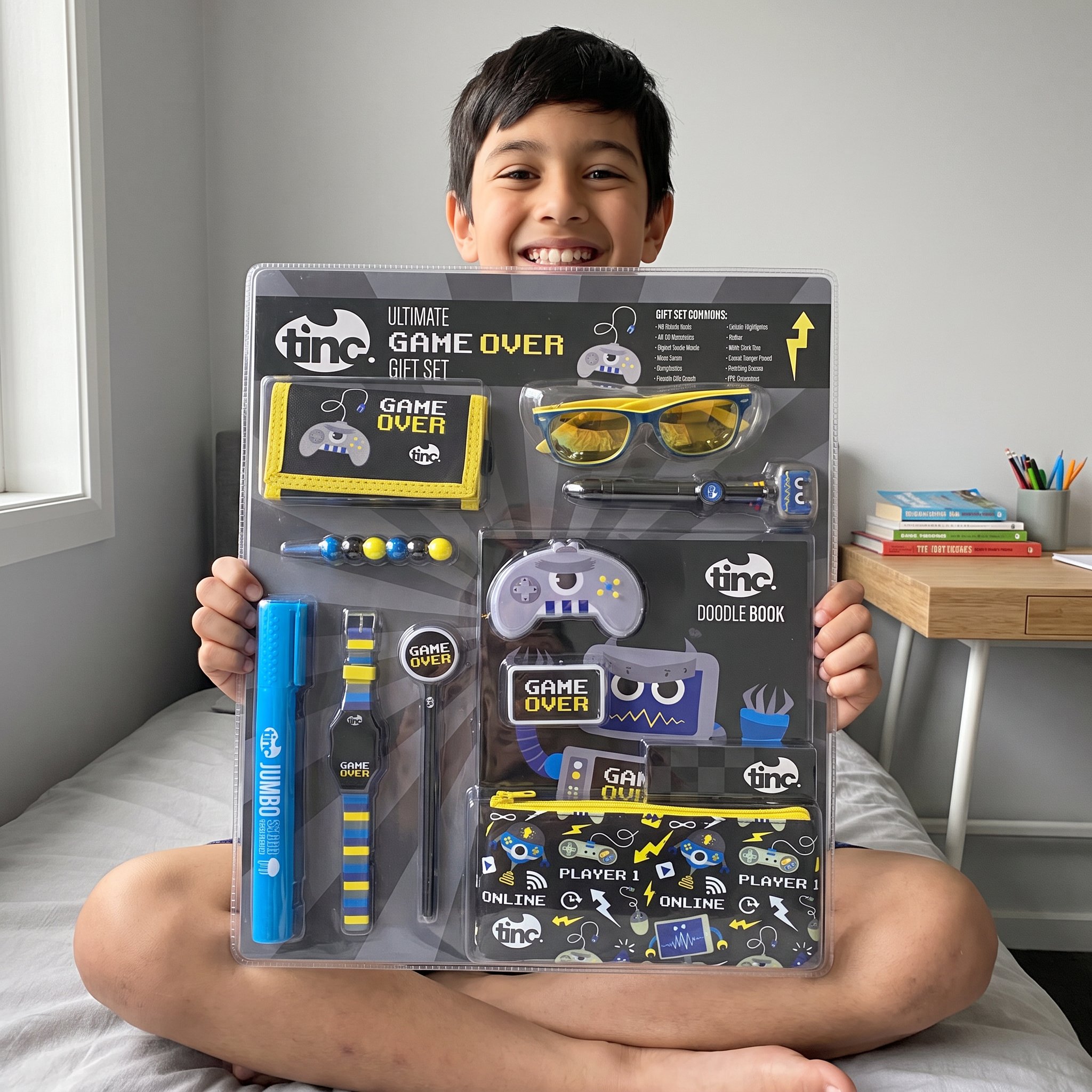Garçon assis en tailleur sur son lit avec le set cadeau Game Over de Tinc sur les genoux