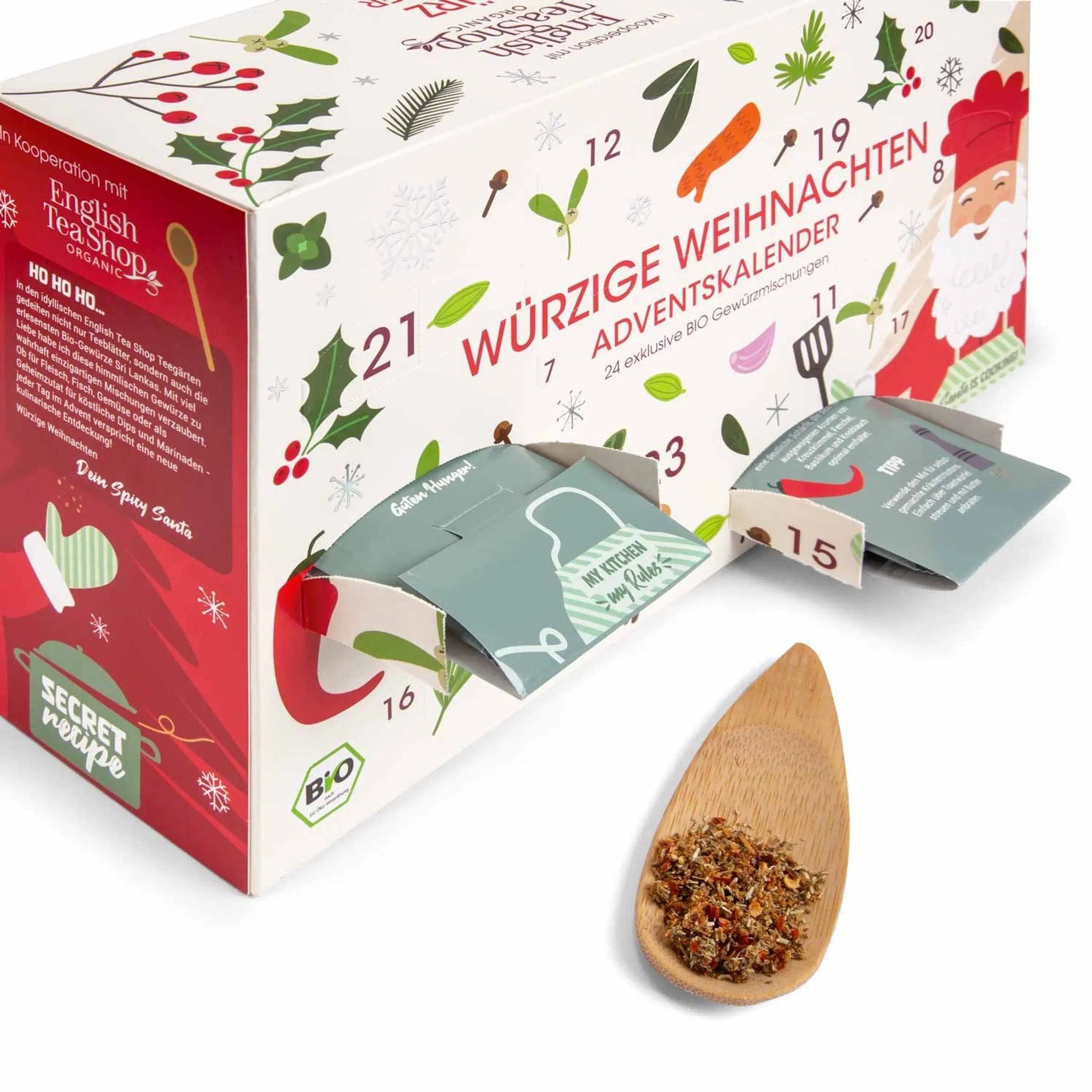 Spice advent calendar opened at the side with spice sachets pulled out and a wooden spoon