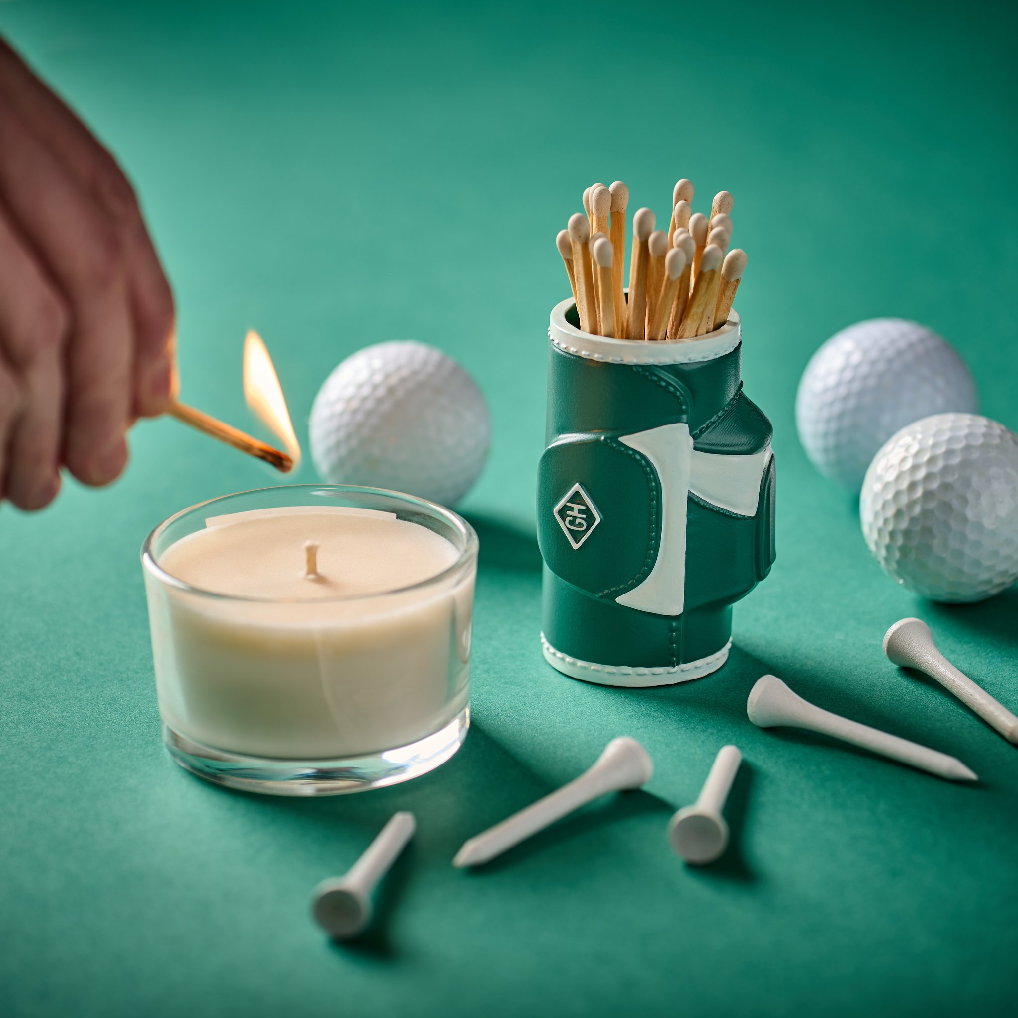 A candle being lit with a match from the golf bag holder