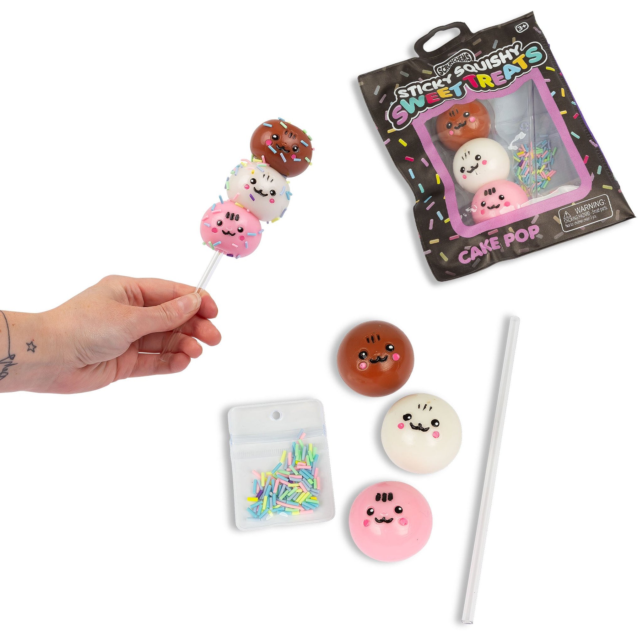 Cake pop Sticky Squishy sullo stecco accanto alla confezione, tre palline squishy, codette e stecco
