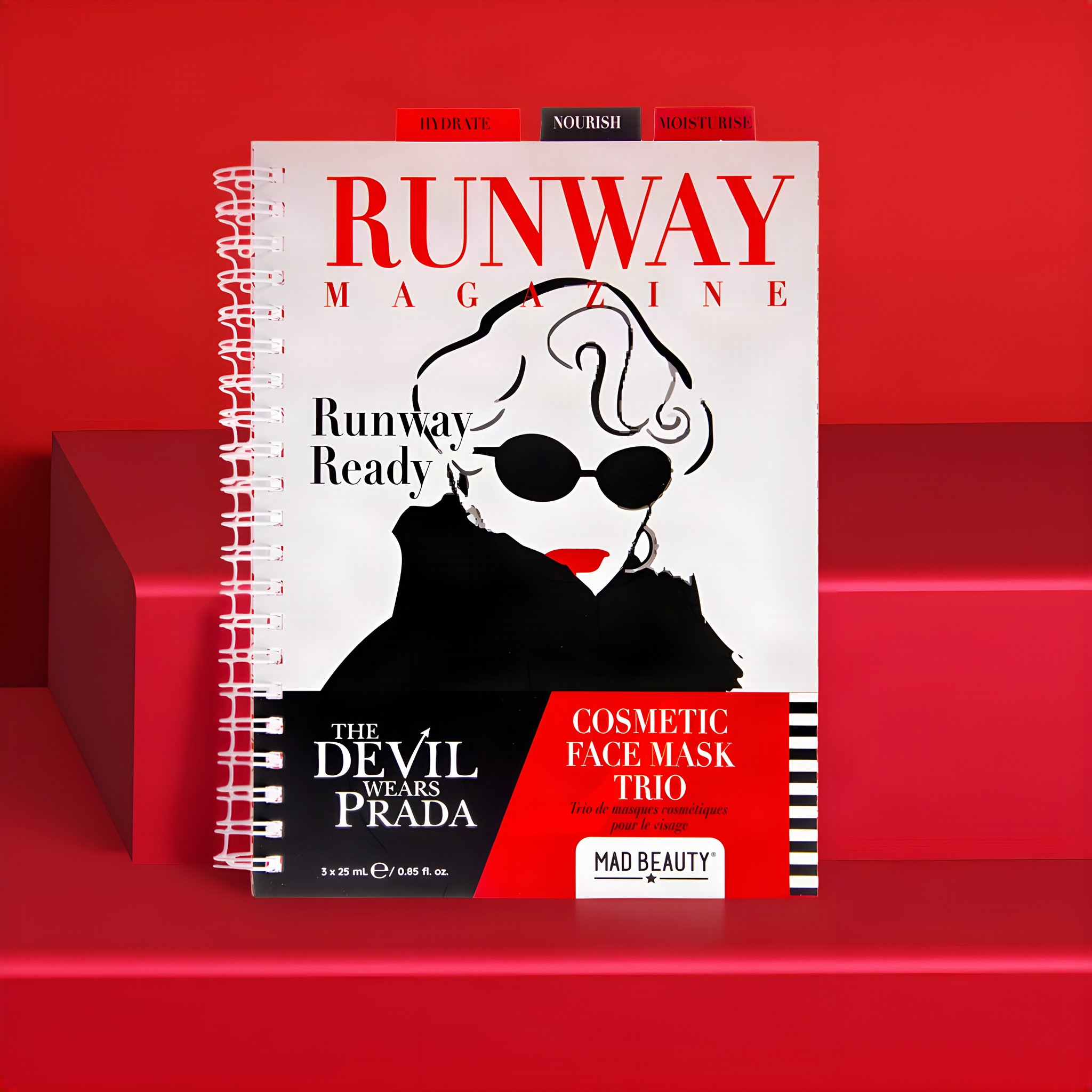The Devil Wears Prada Tuchmasken-Trio in der Verpackung im Look des Runway-Magazins, vor Rot inszeniert