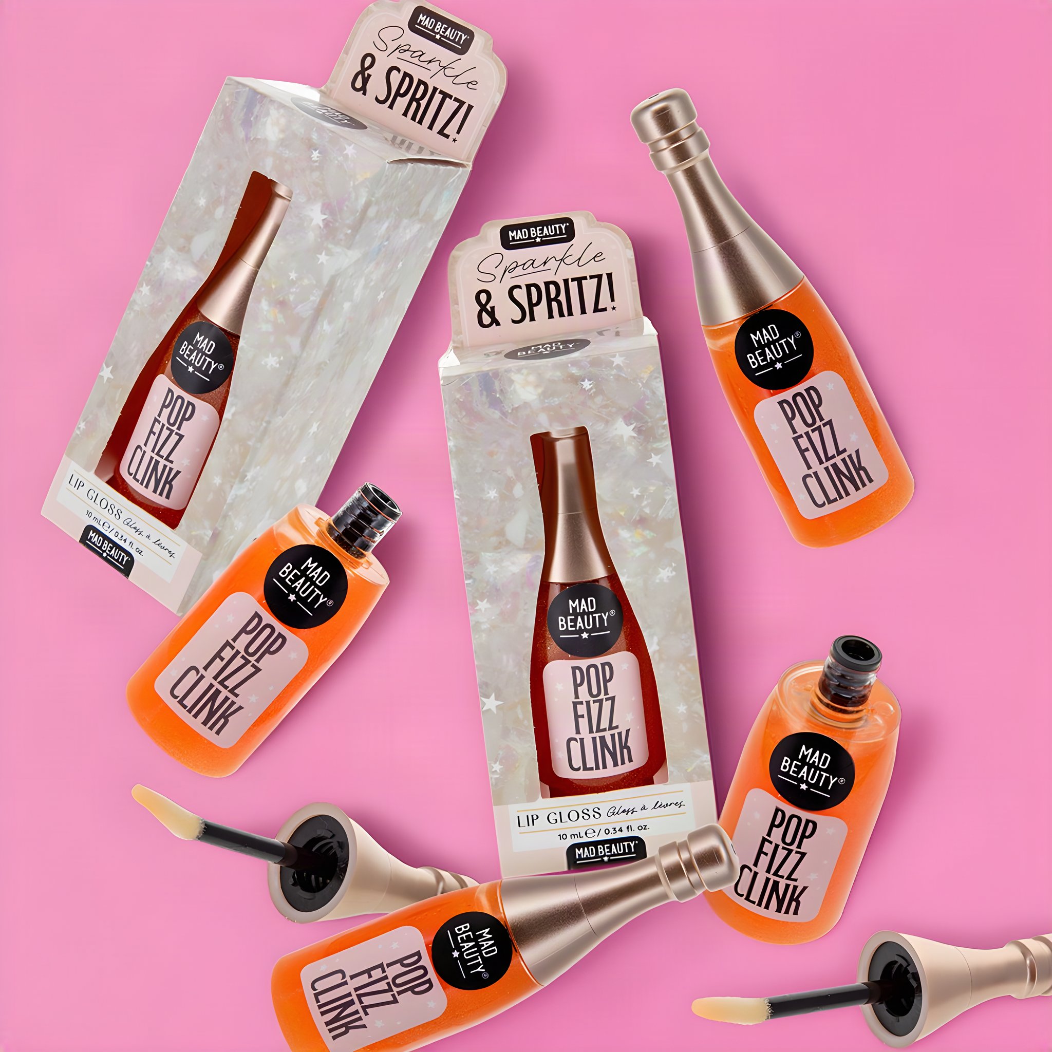 Glitzer-Lipgloss in Sektflaschen-Form, mehrere Fläschchen verstreut um die Verpackung «Pop Fizz Clink»