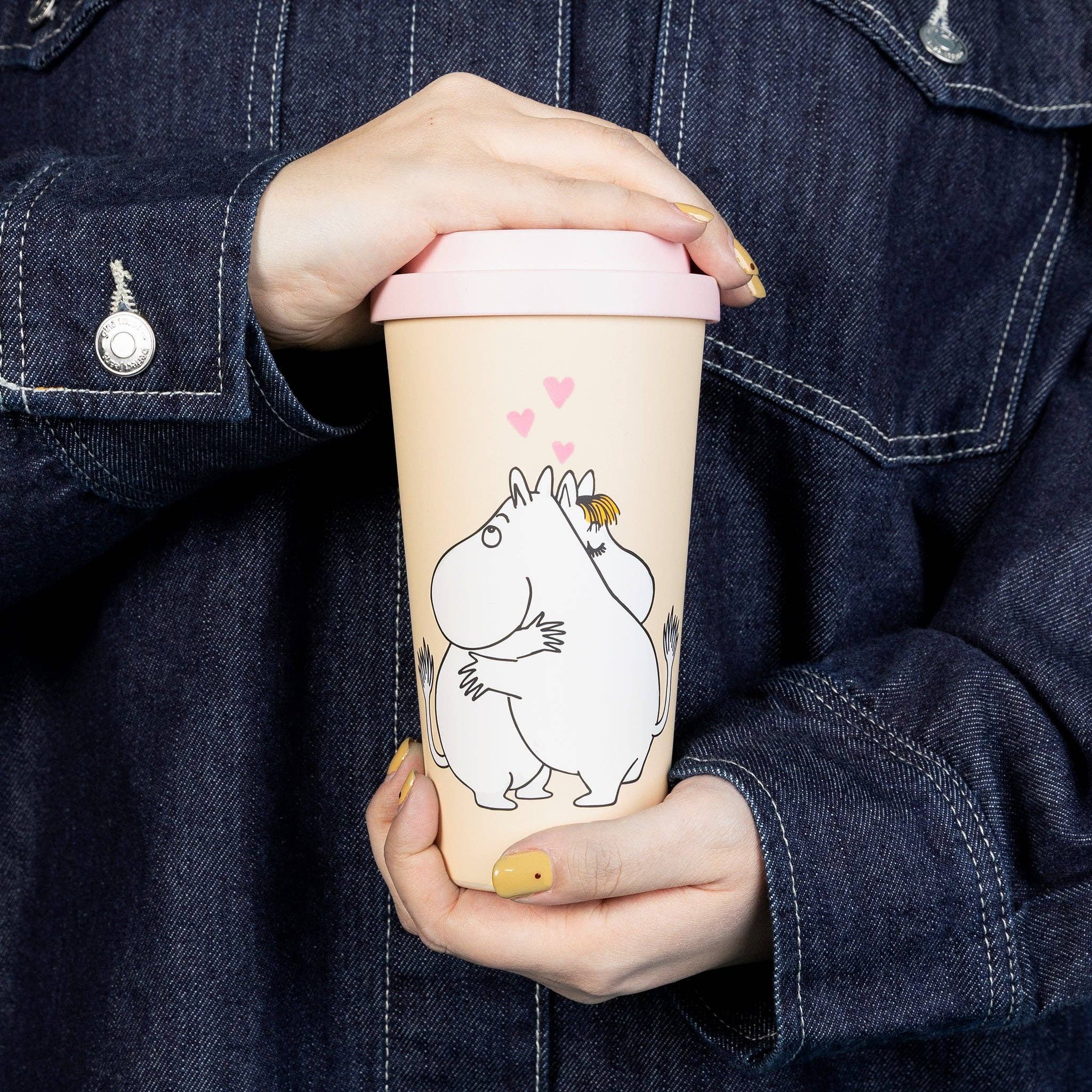 Moomin Love take-away mug with pink lid held in two hands