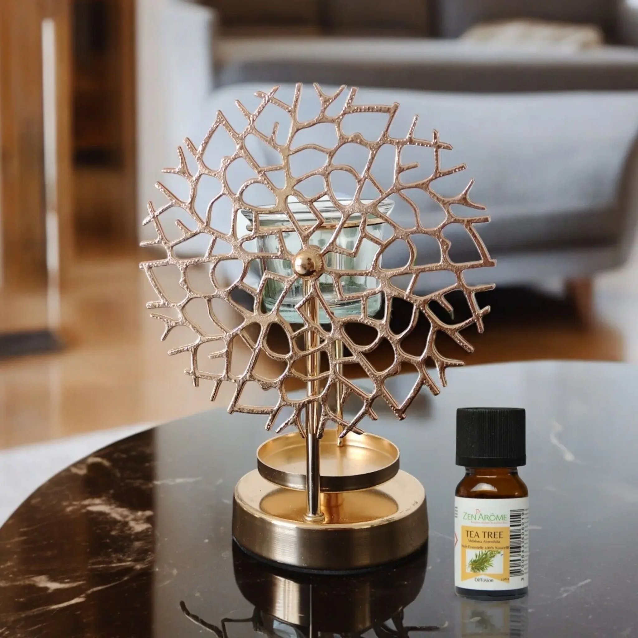 Coral pattern oil burner on a marble top next to a small bottle of essential oil