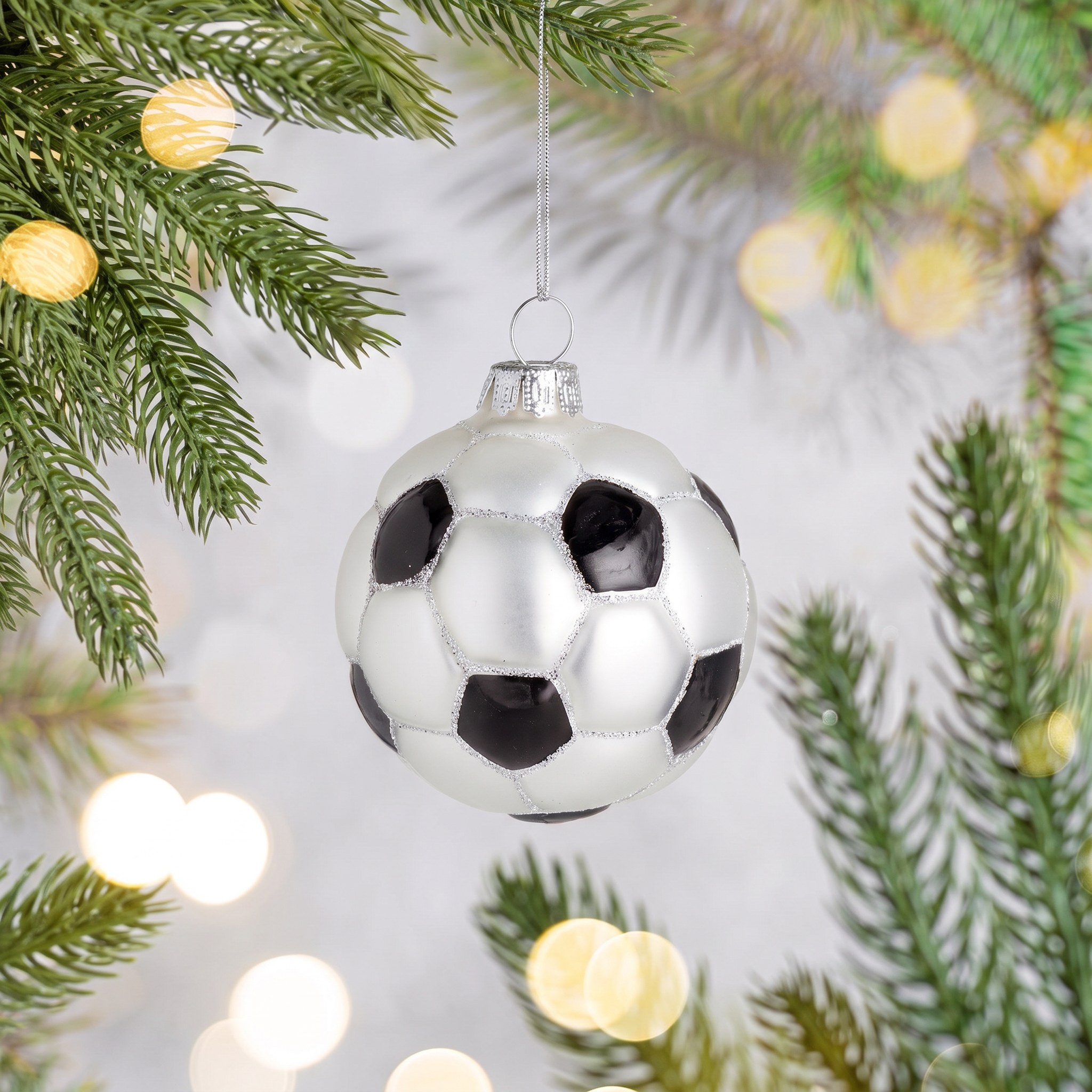 Pallina di Natale Calcio di Sass & Belle su un ramo di abete con luci calde