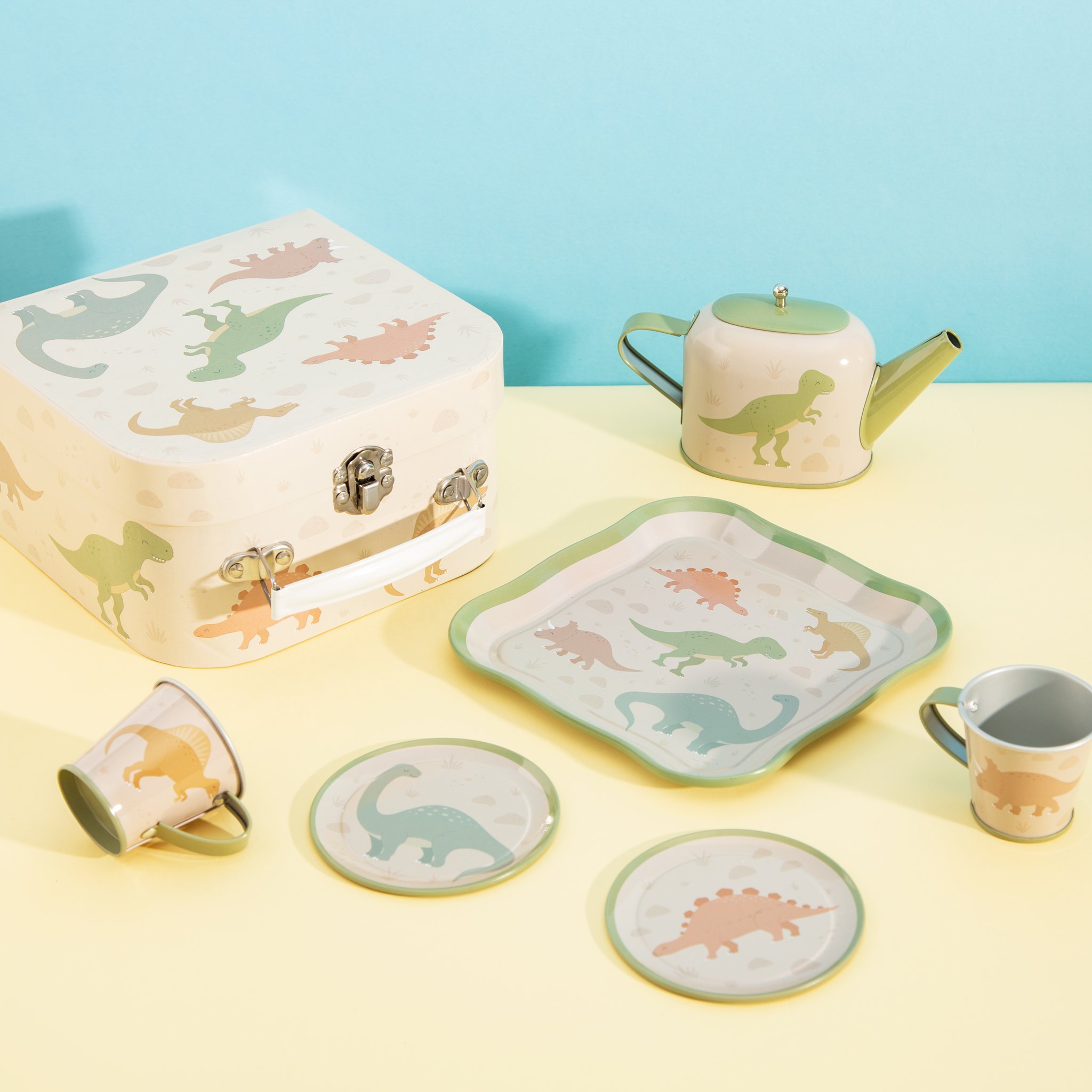 Desert dino kids tea set by Sass & Belle with case, plates, cups and teapot on yellow