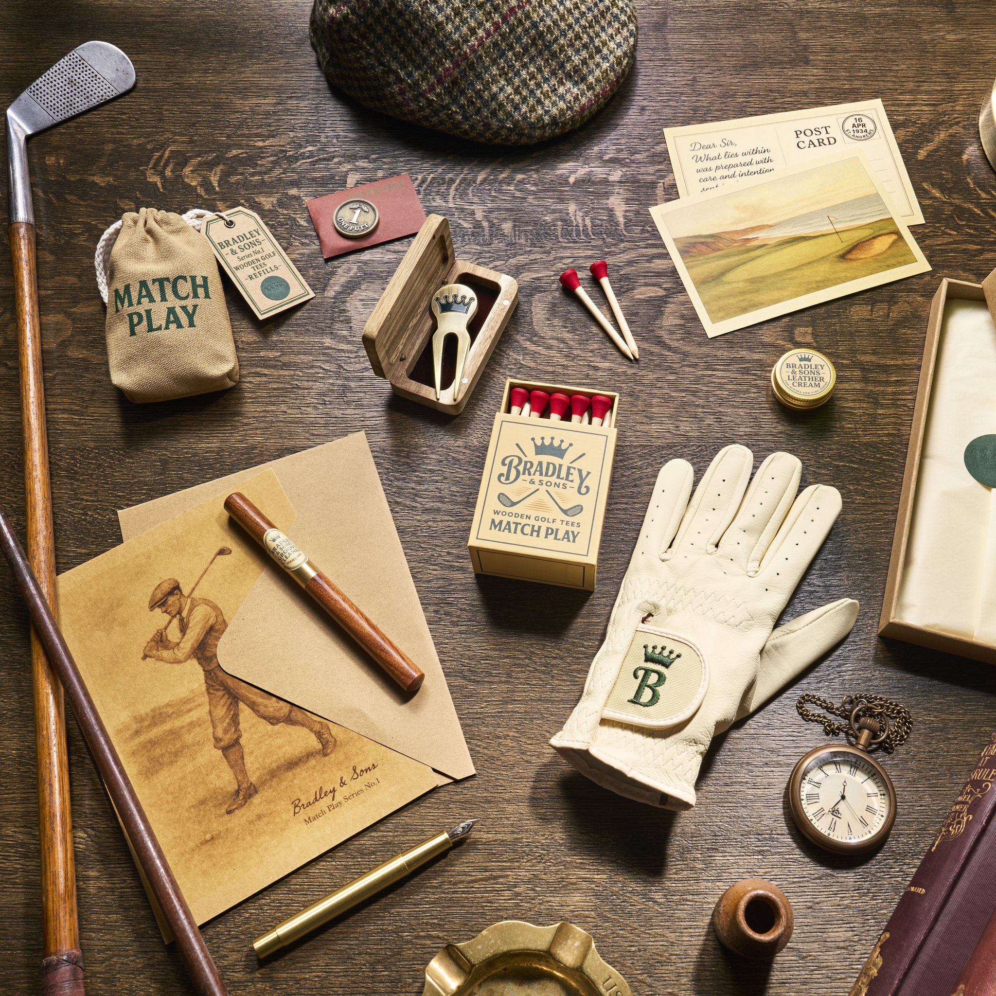 Der Inhalt des Founder's Parcel ausgebreitet: Lederhandschuh, Birken-Tees, Groove Cleaner und Divot-Tool