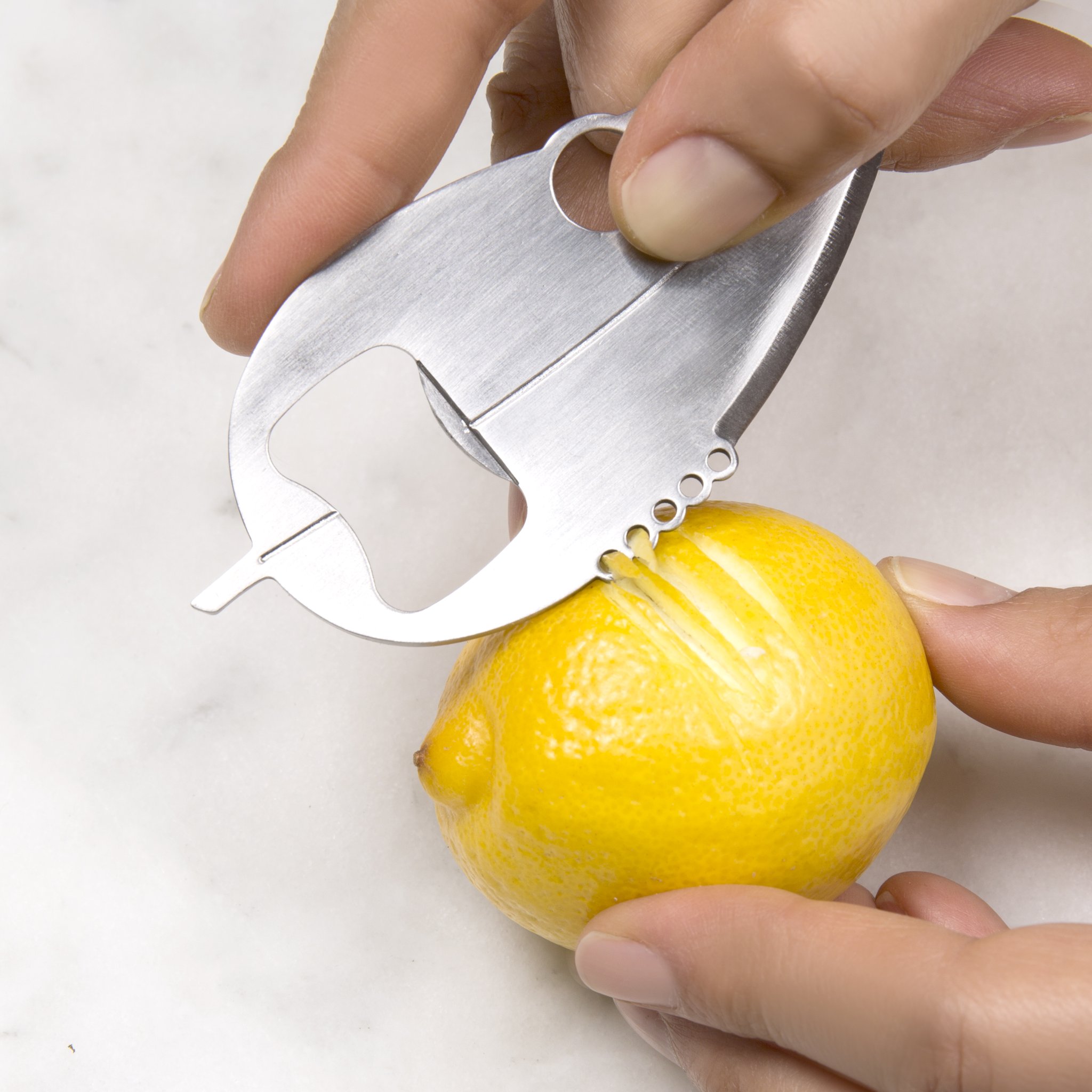 Kitchen multitool used as a citrus squeezer on half a lemon