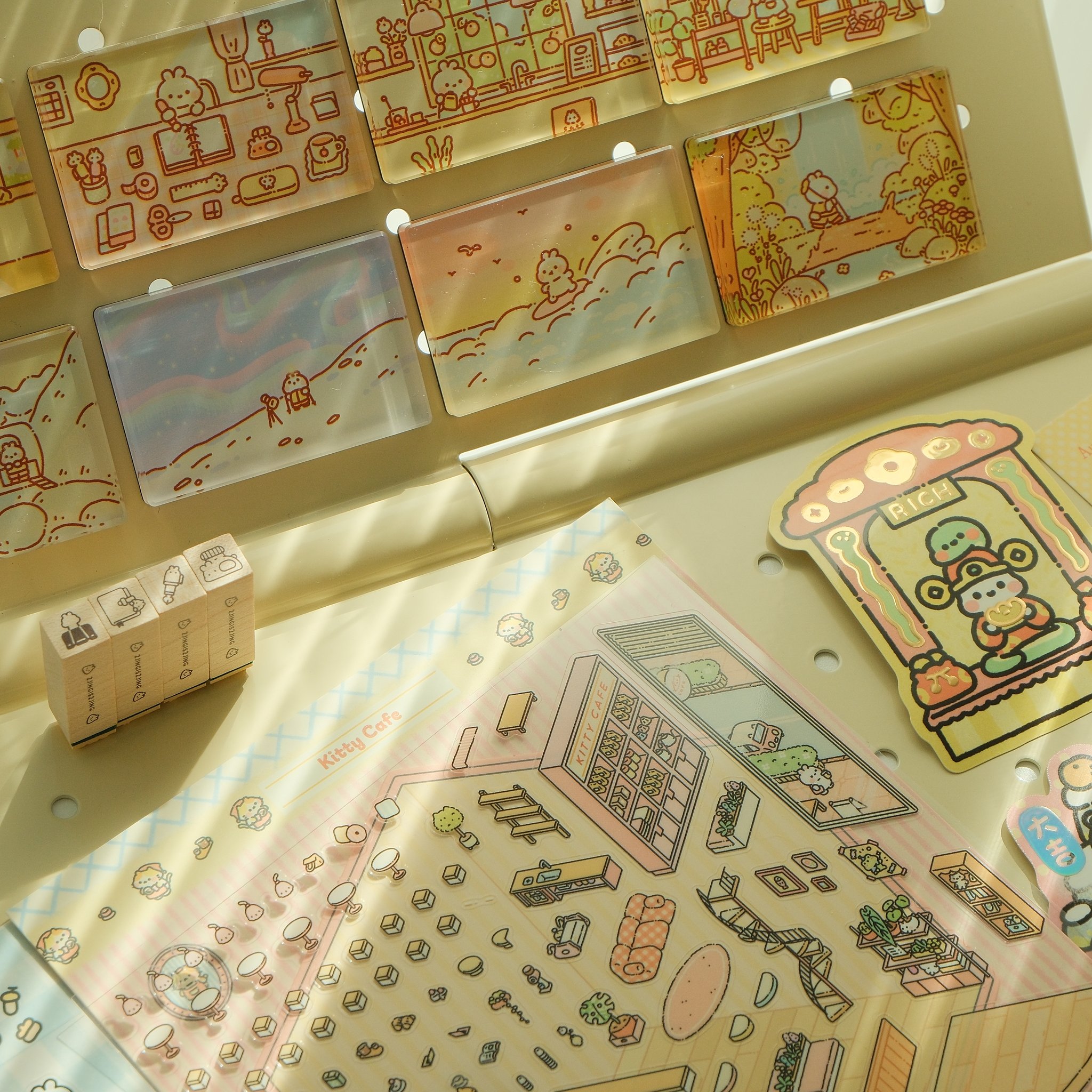 Room card and sticker sheet of the Kitty Cafe kit beside stamps and collector cards