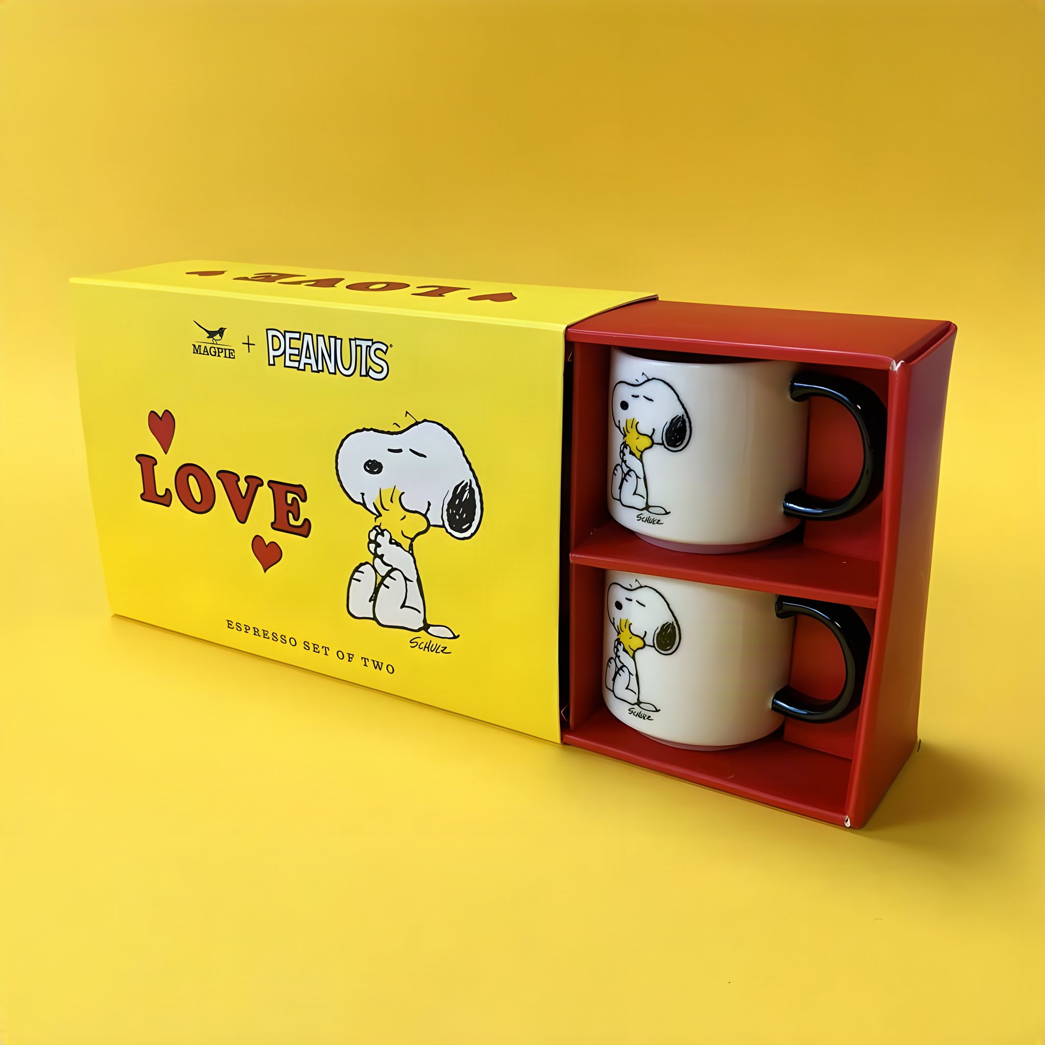 Geöffnete gelbe Geschenkbox des Snoopy Espresso-Sets mit beiden Tassen im Einsatz