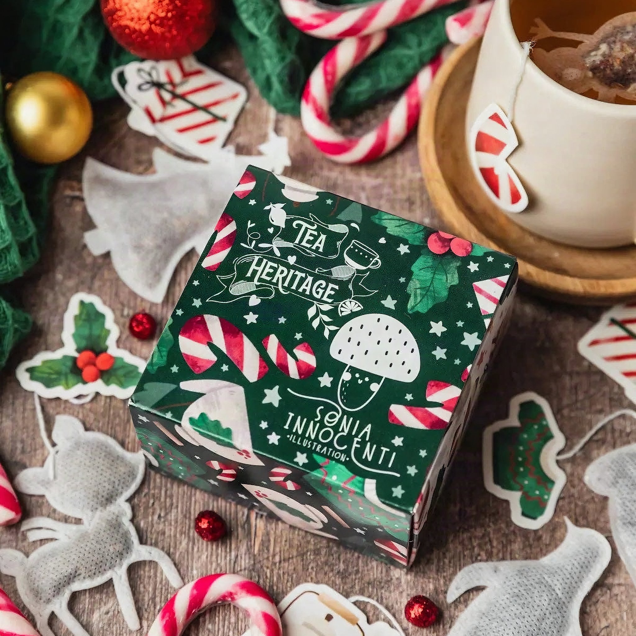 Cofanetto di Natale Tea Heritage verde illustrato da Sonia Innocenti tra bastoncini di zucchero e bustine