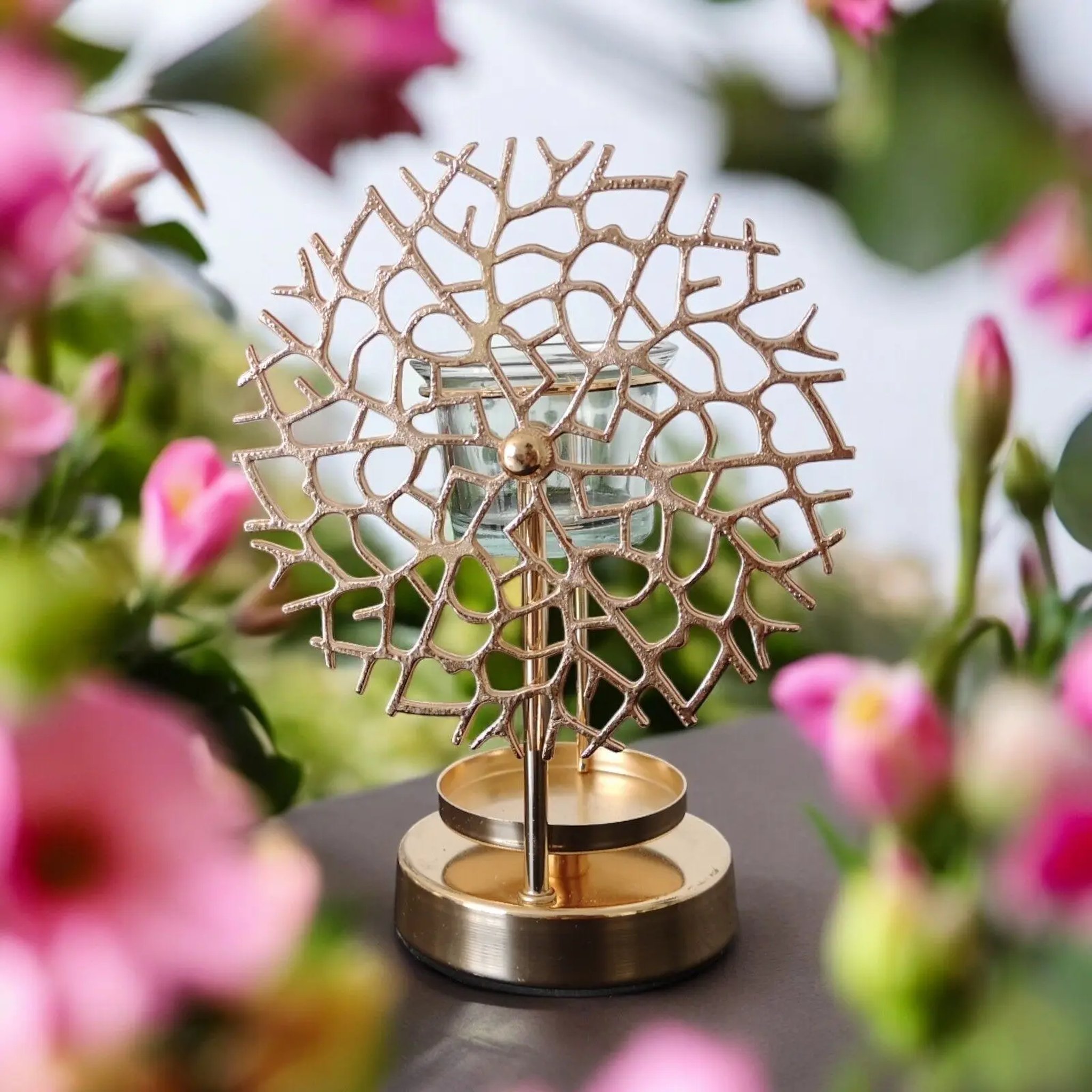 Oil burner with fine coral-shaped metal lattice between pink flowers