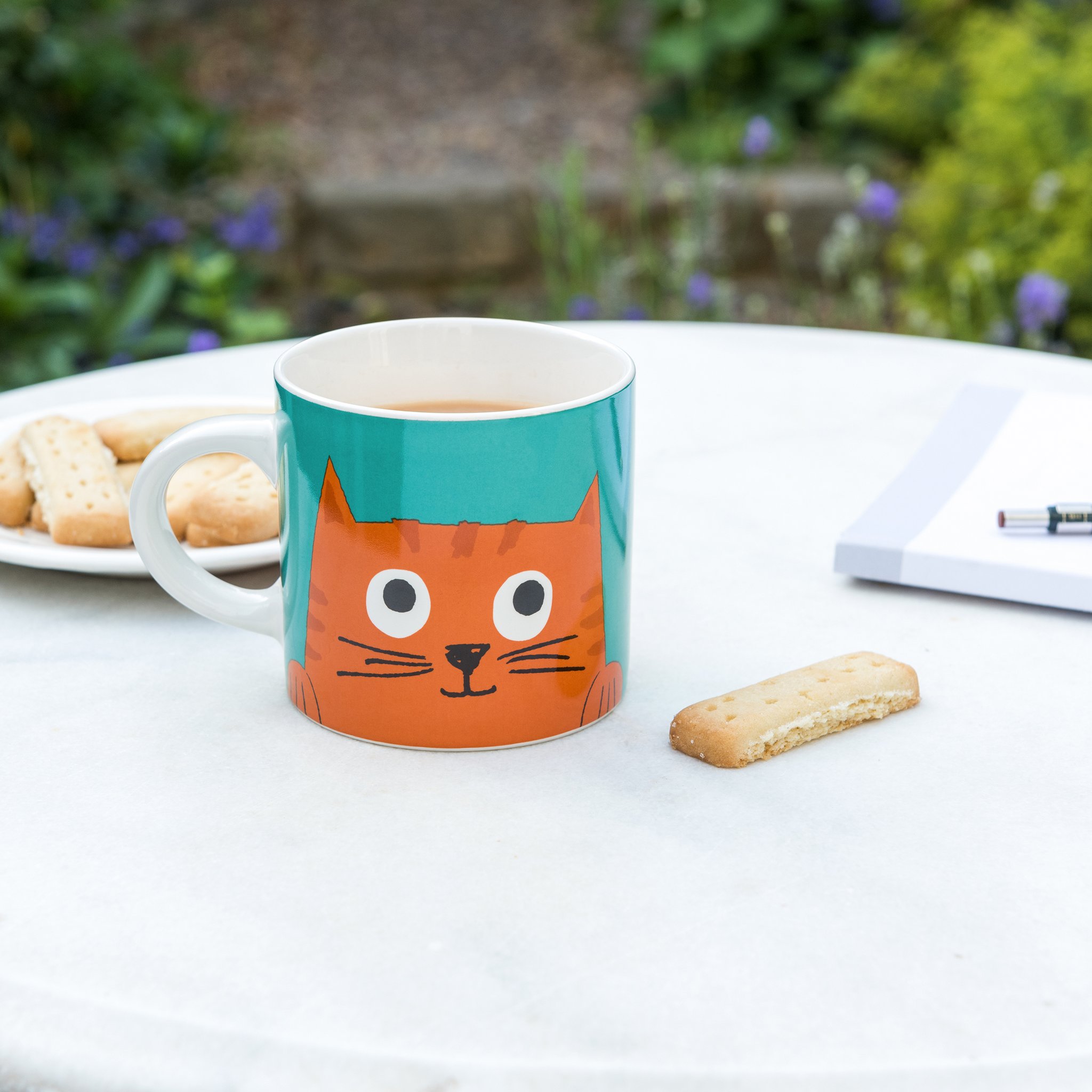 Tasse Chester avec thé et biscuit sur la table de jardin