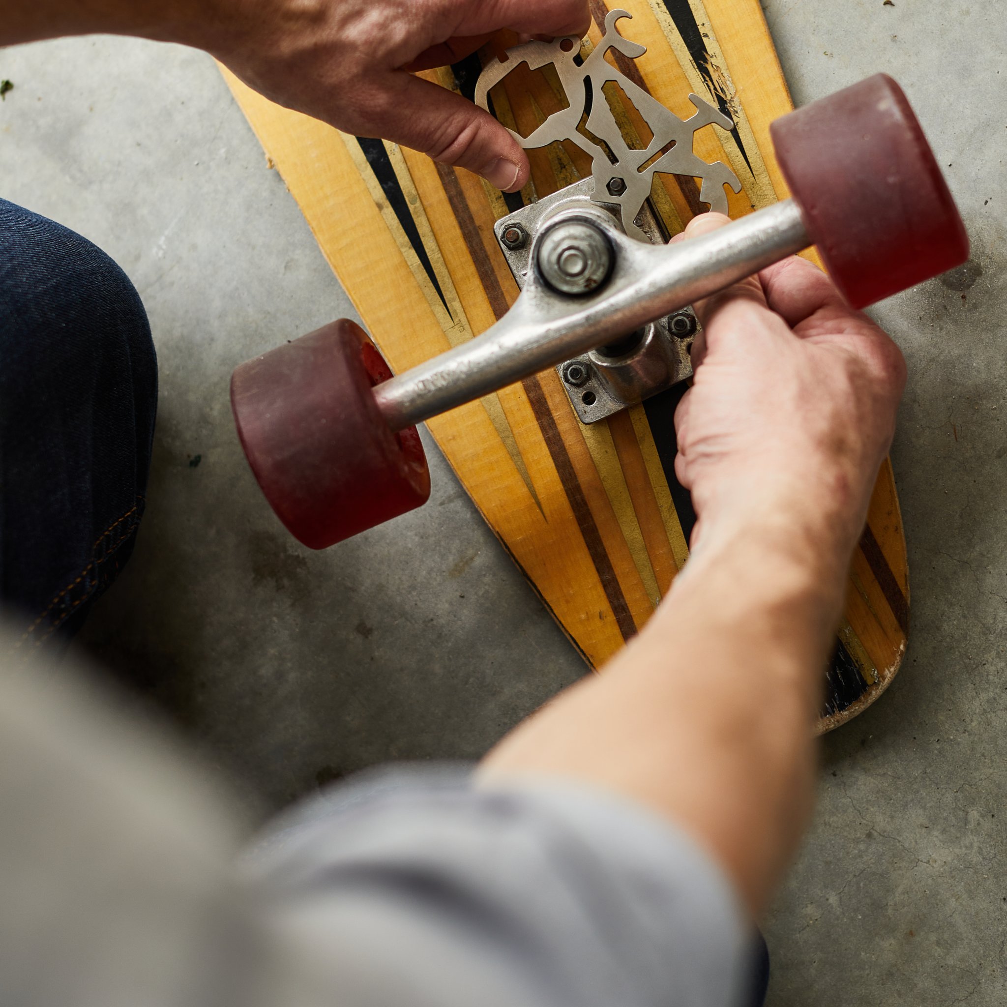 Close view from above of the Mini Bicycle Multi-Tool in hand while a skateboard is being adjusted