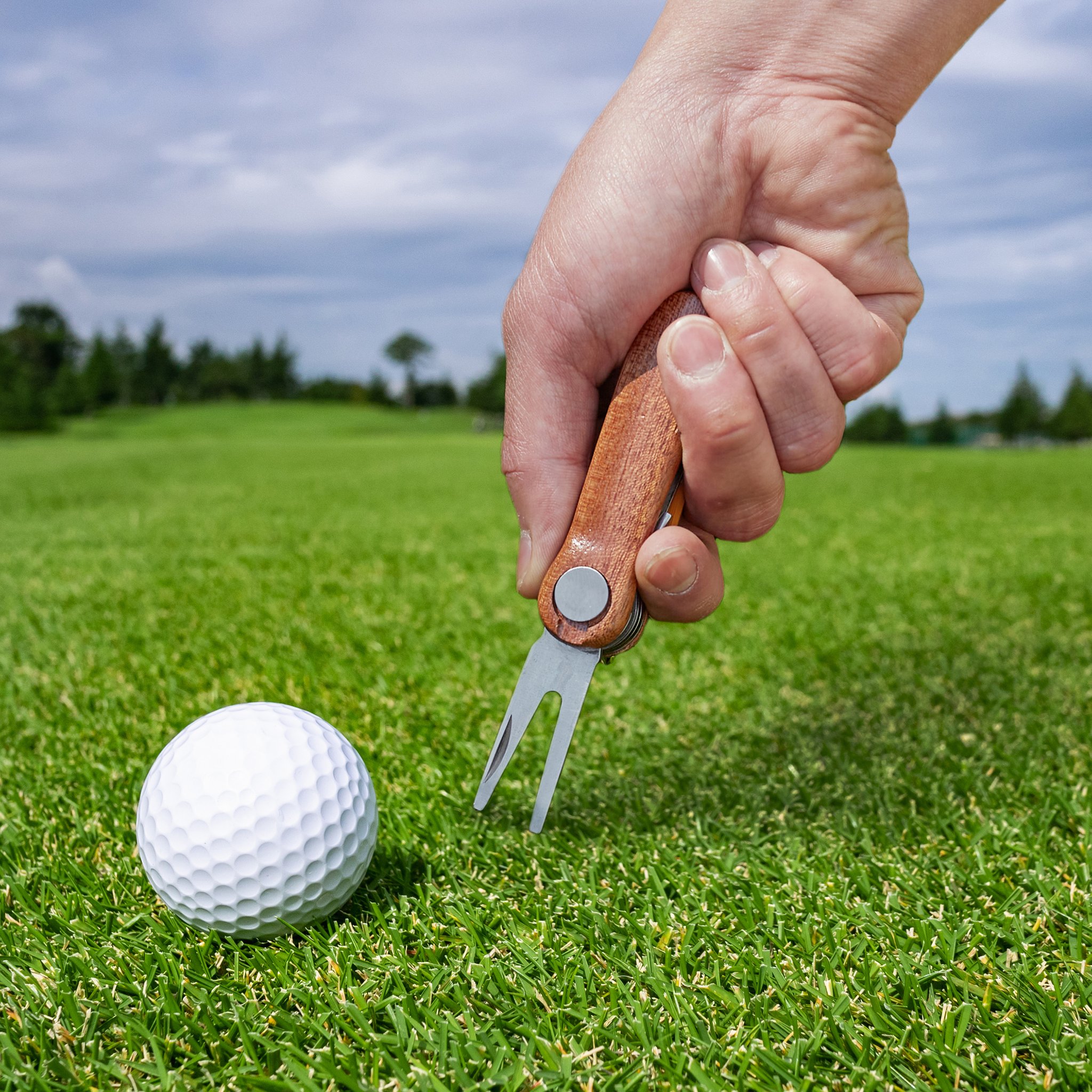 Outil de golf réparant un pitch sur le green avec la fourchette