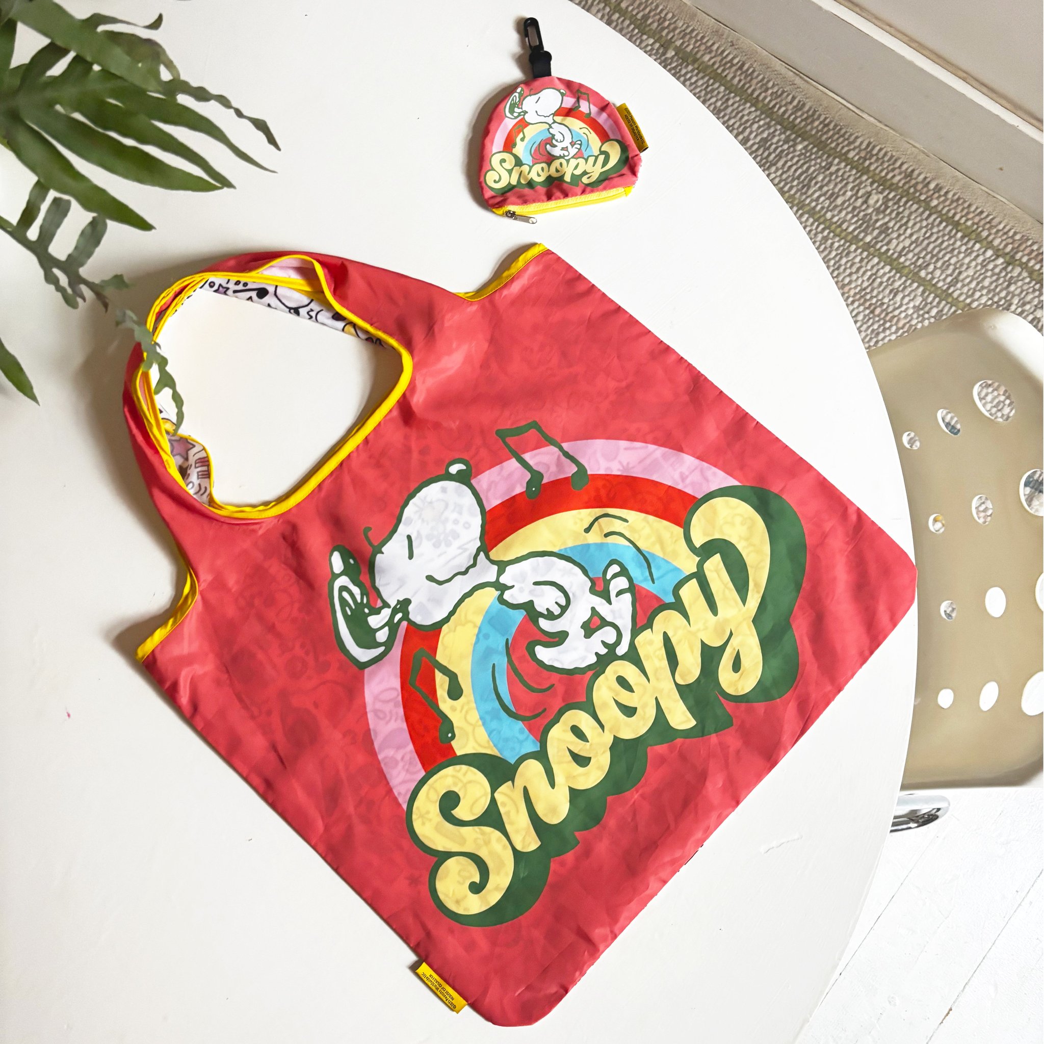Foldable Snoopy shopping bag with matching clip-on pouch on a table