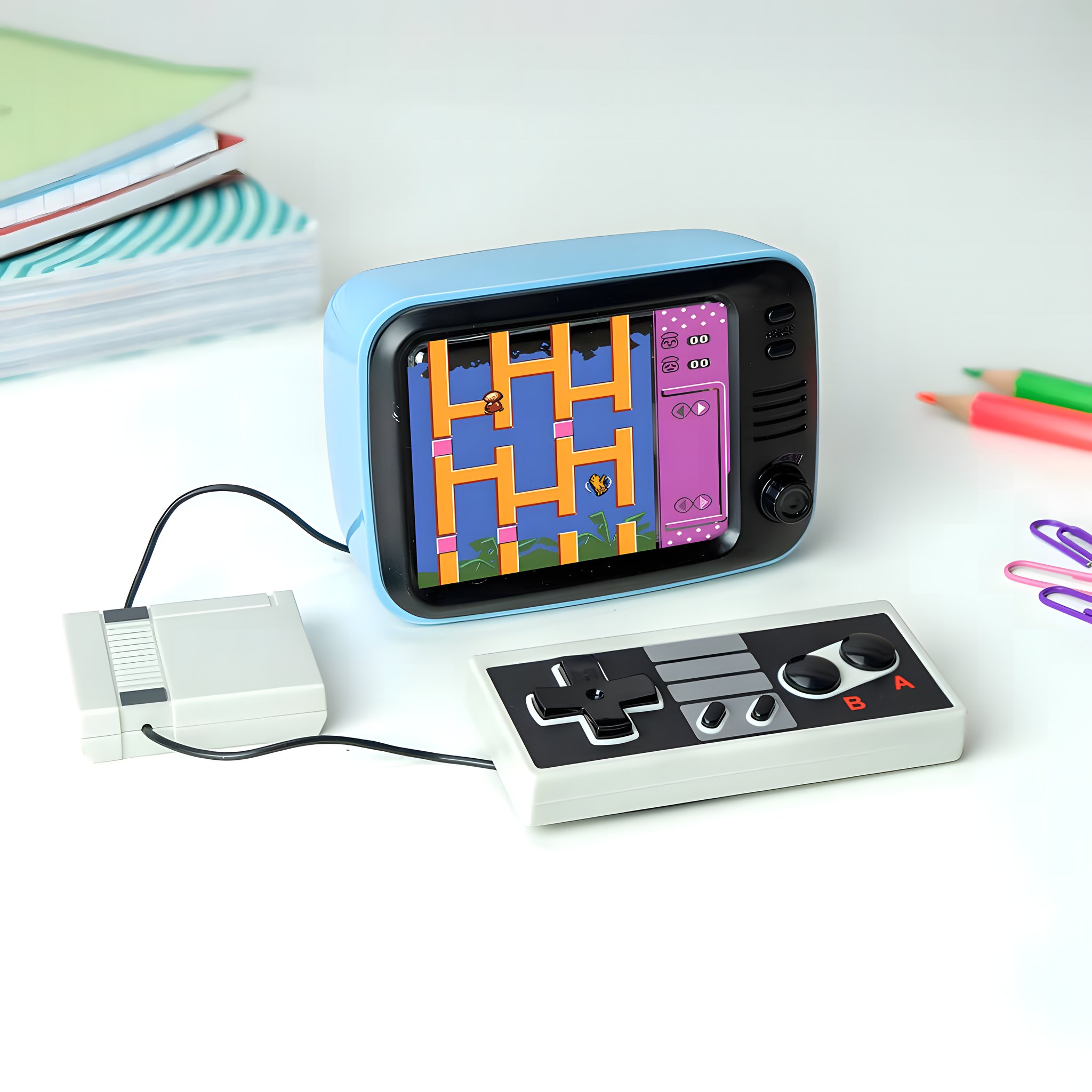 Retro-Spielkonsole mit Controller auf einem Schreibtisch neben Heften und Stiften