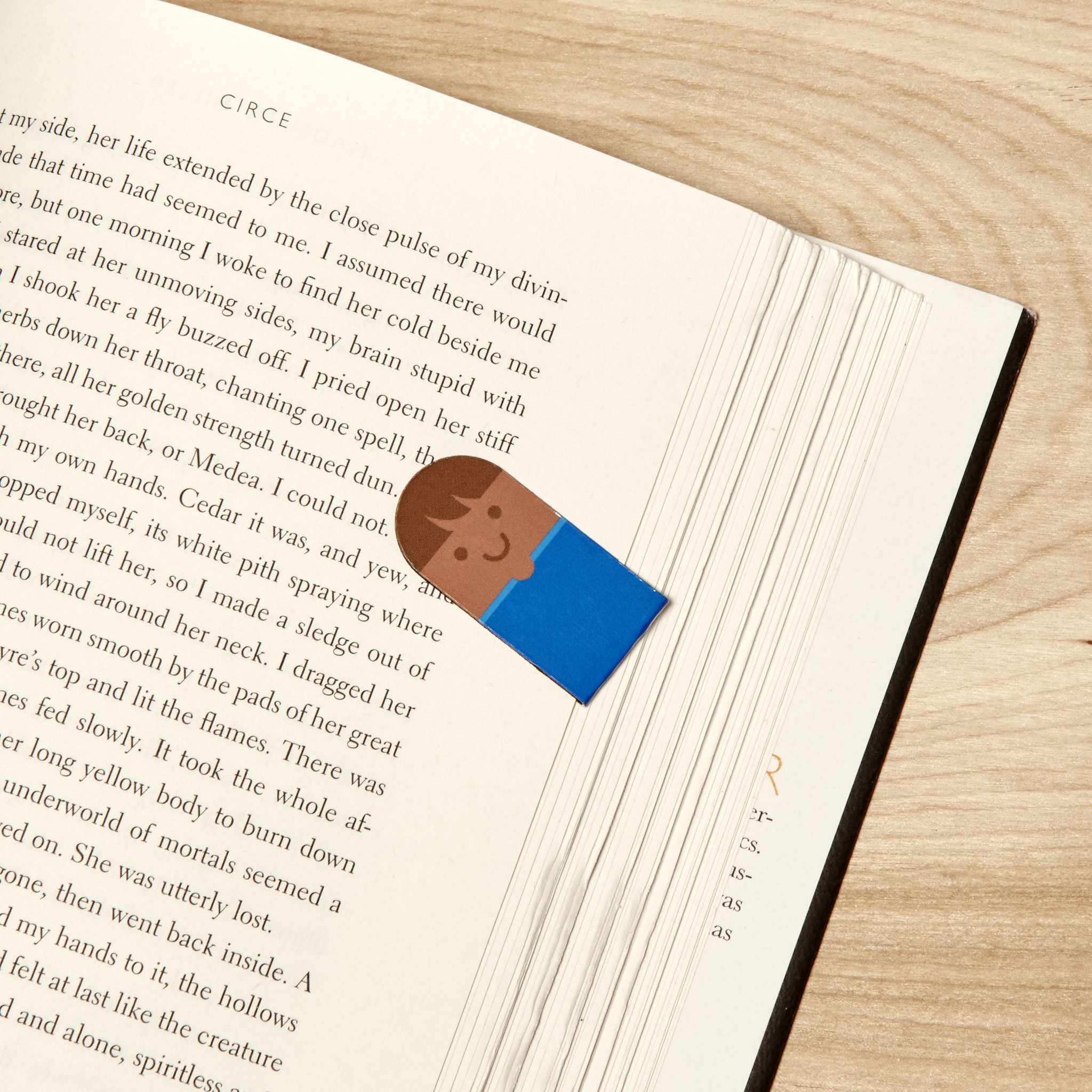Bookmark with blue figure peeking out of the open book