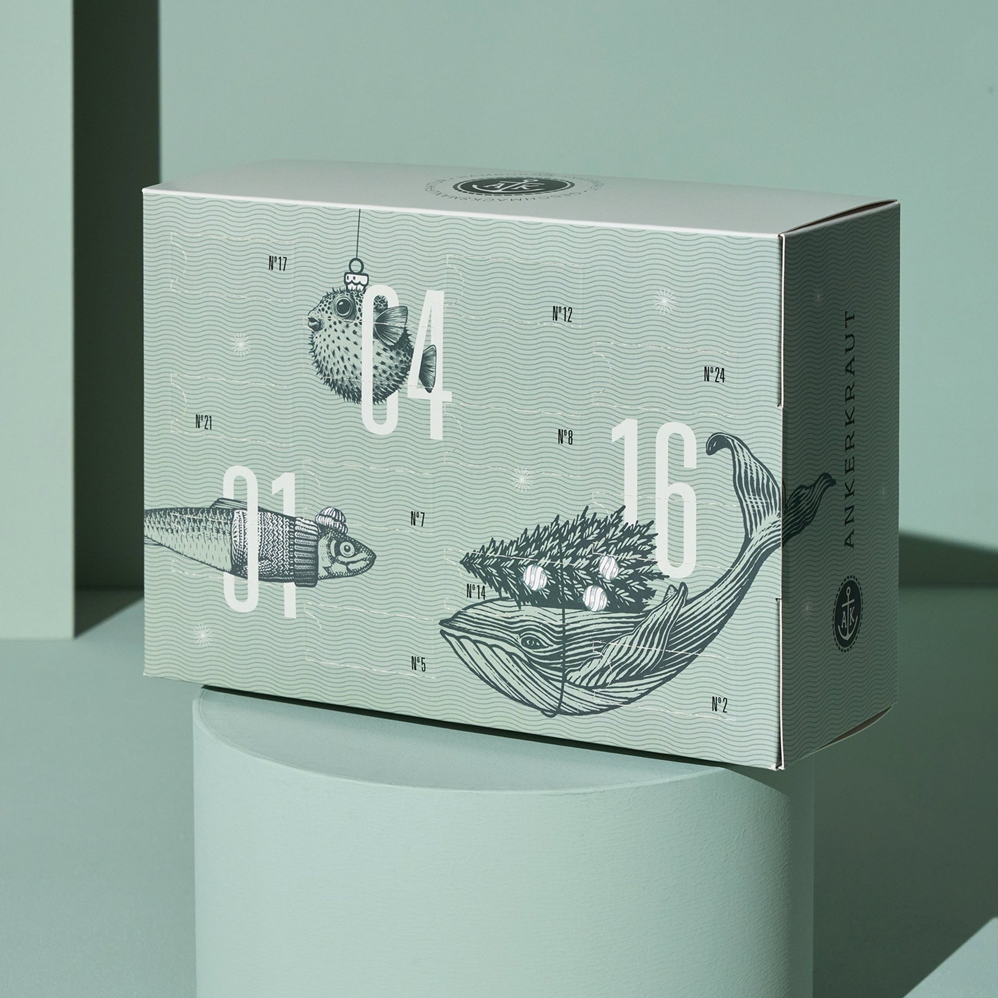 Der Lütte Adventskalender auf einem mintfarbenen Podest mit Wal- und Fischillustrationen