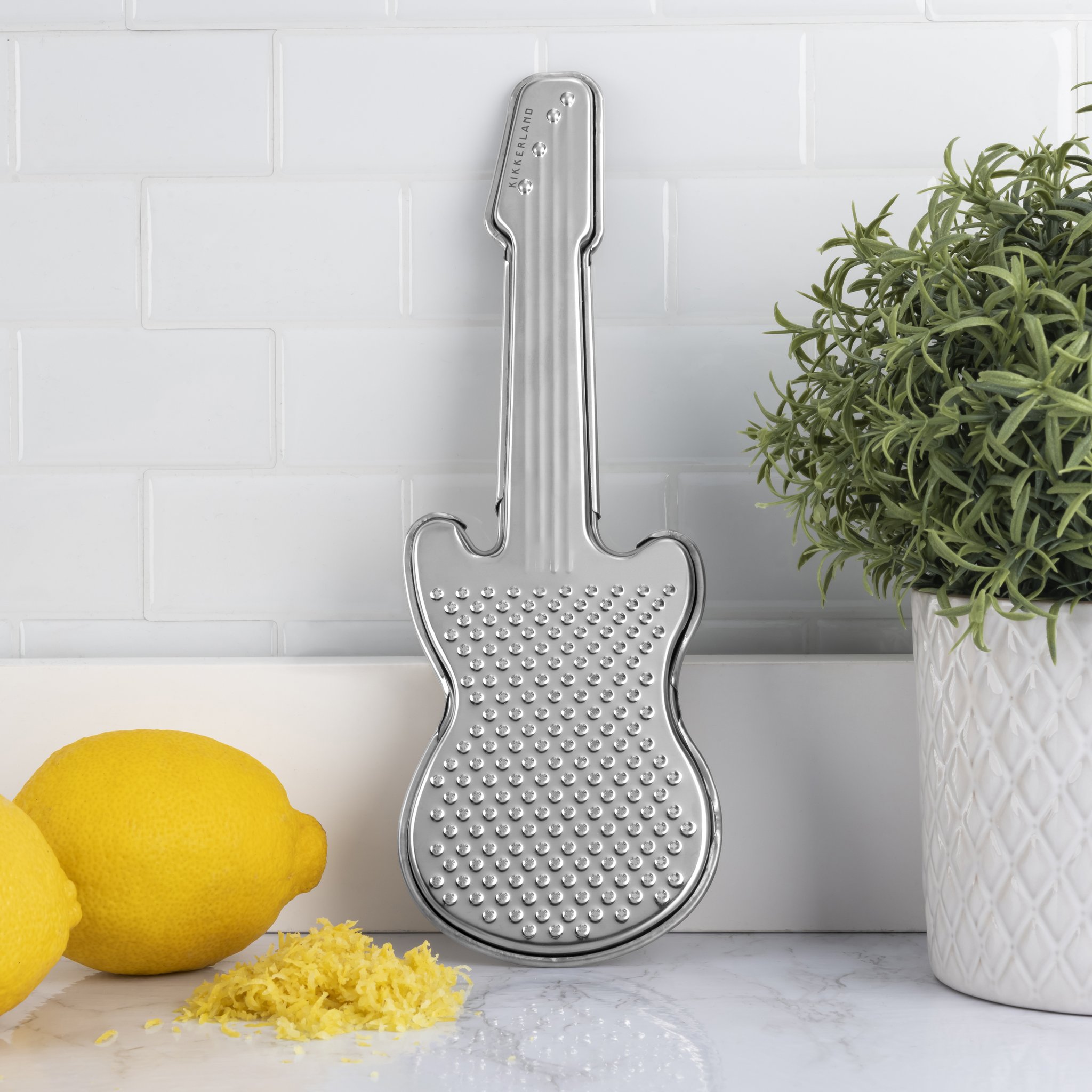 Râpe guitare appuyée au mur de la cuisine près d'un citron et de zeste
