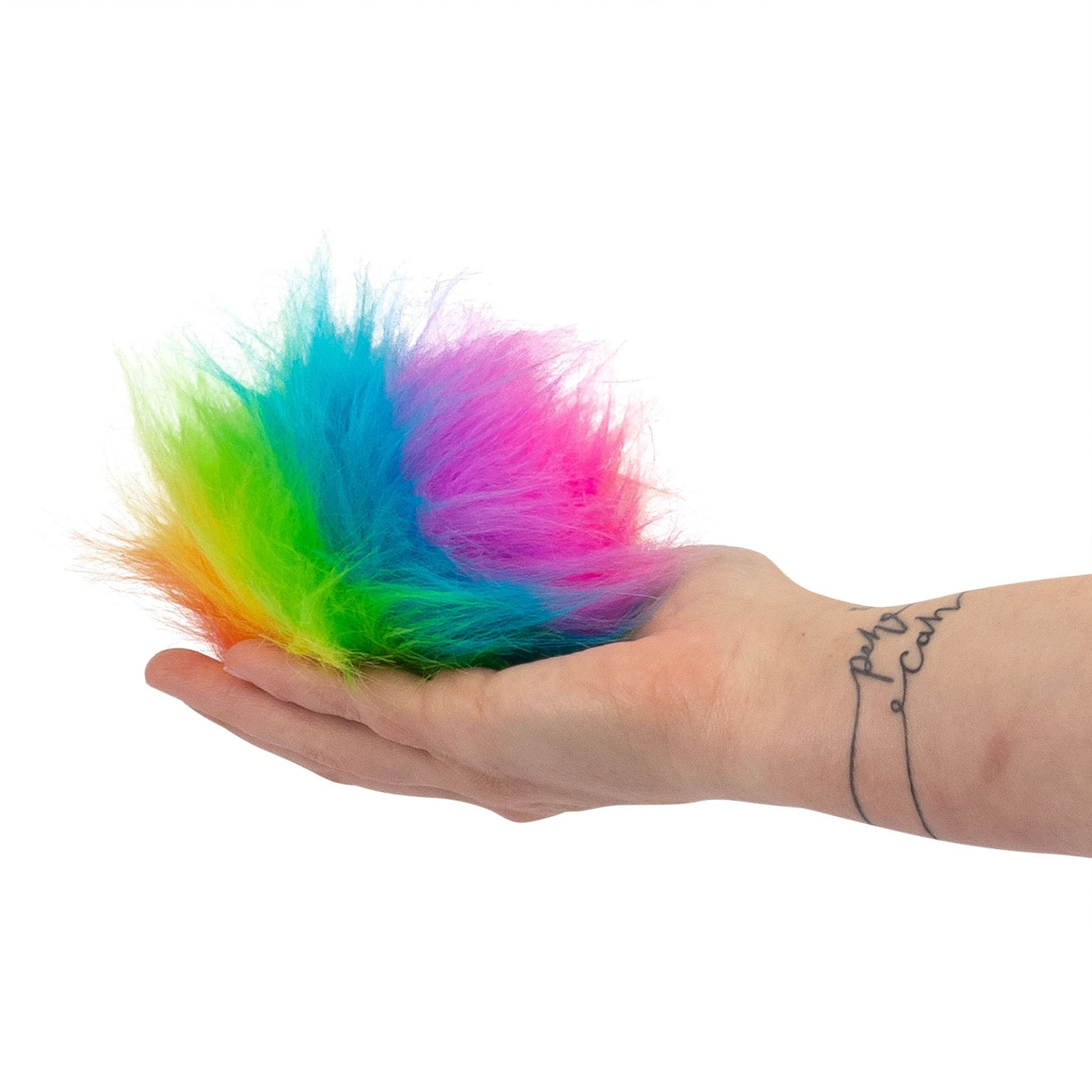 Furry Sugar Squish Ball mit Regenbogenfell liegt in einer offenen Hand