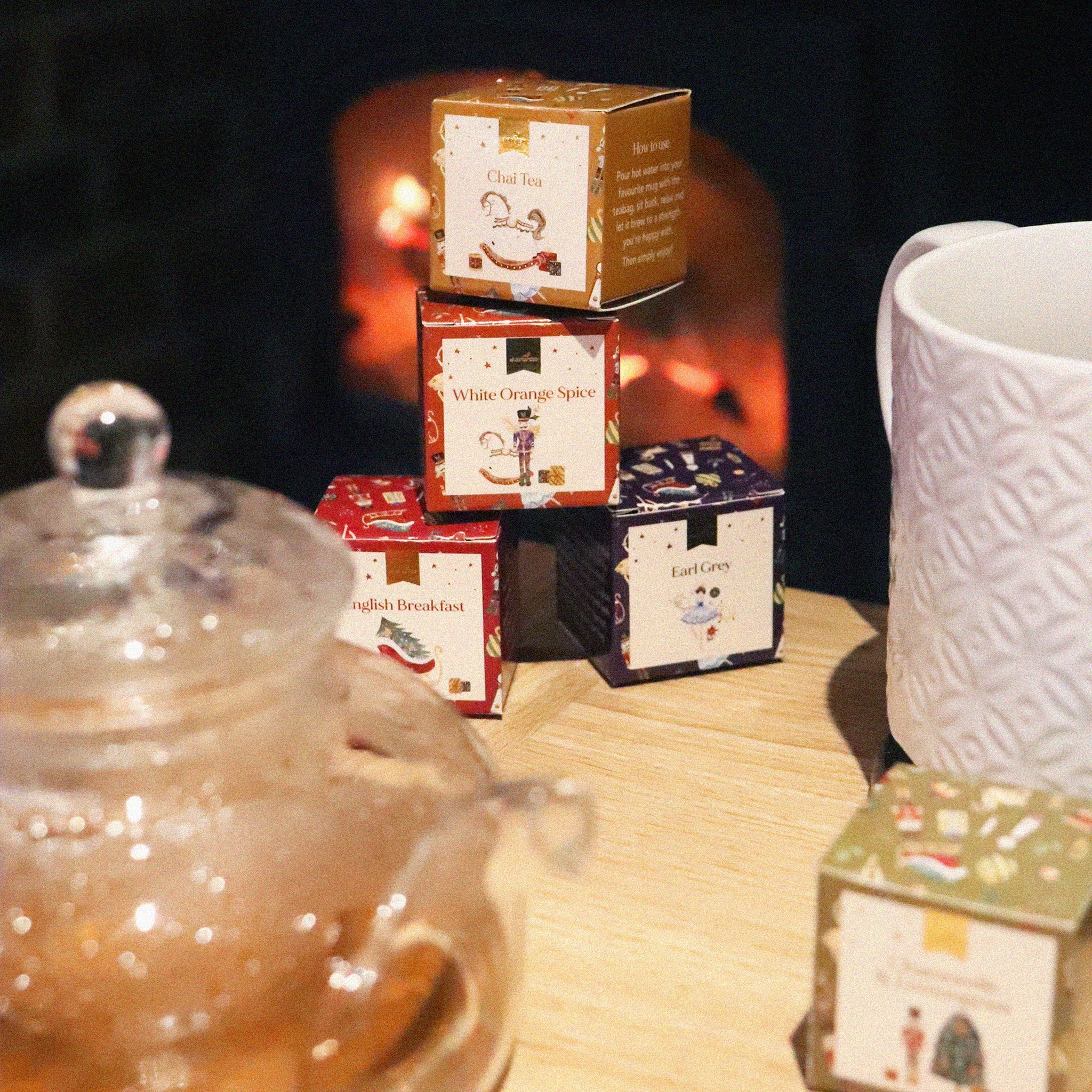 Stacked tea cubes from the Nutcracker set next to a glass teapot by the fireplace