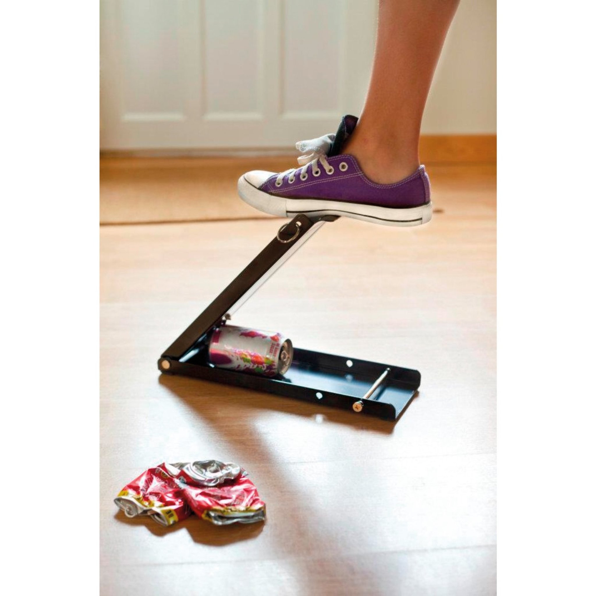 Can crusher in action — crushing a can with foot