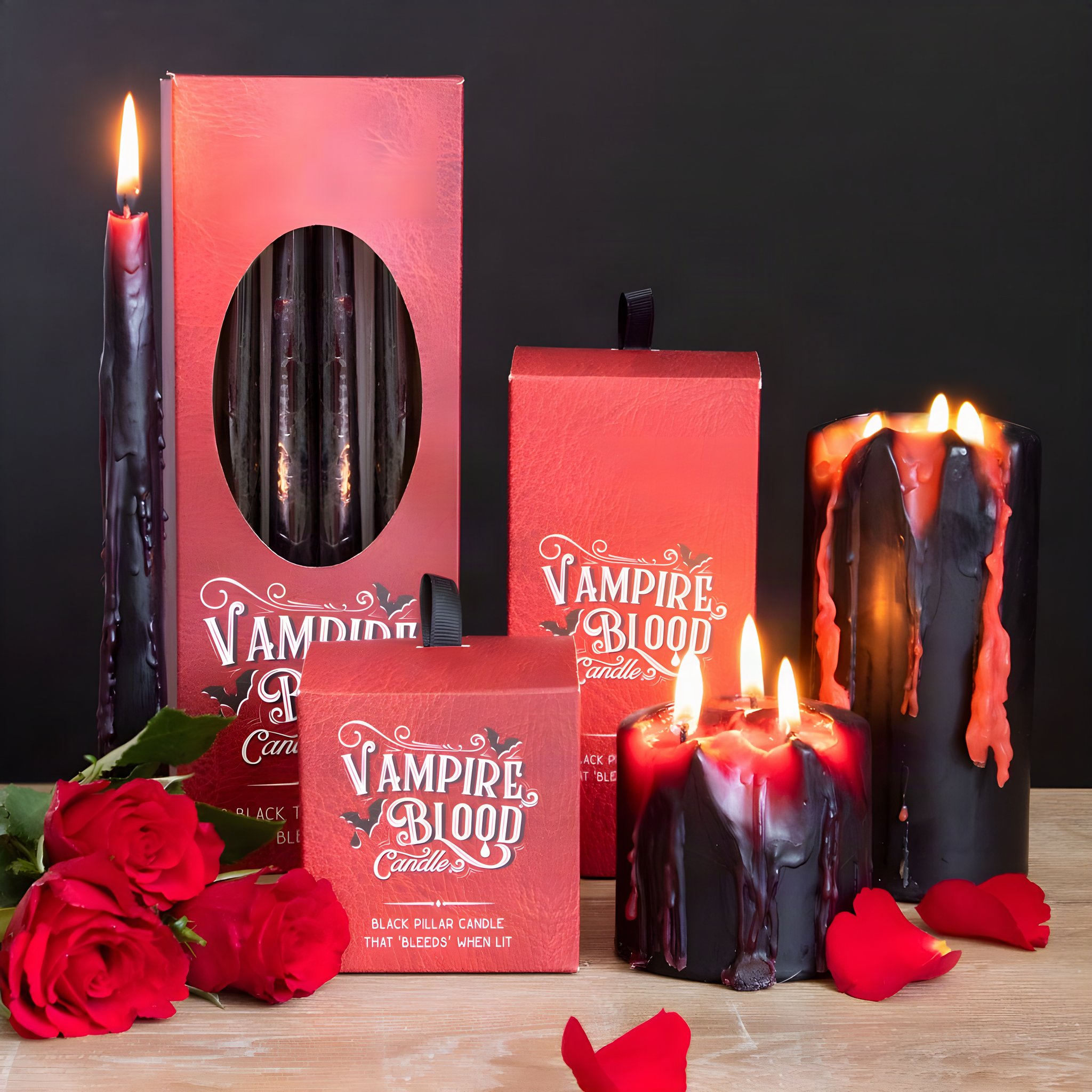 Brennende Vampirblut-Kerzen mit roten Wachsspuren neben Verpackungen und Rosen in dunkler Szene