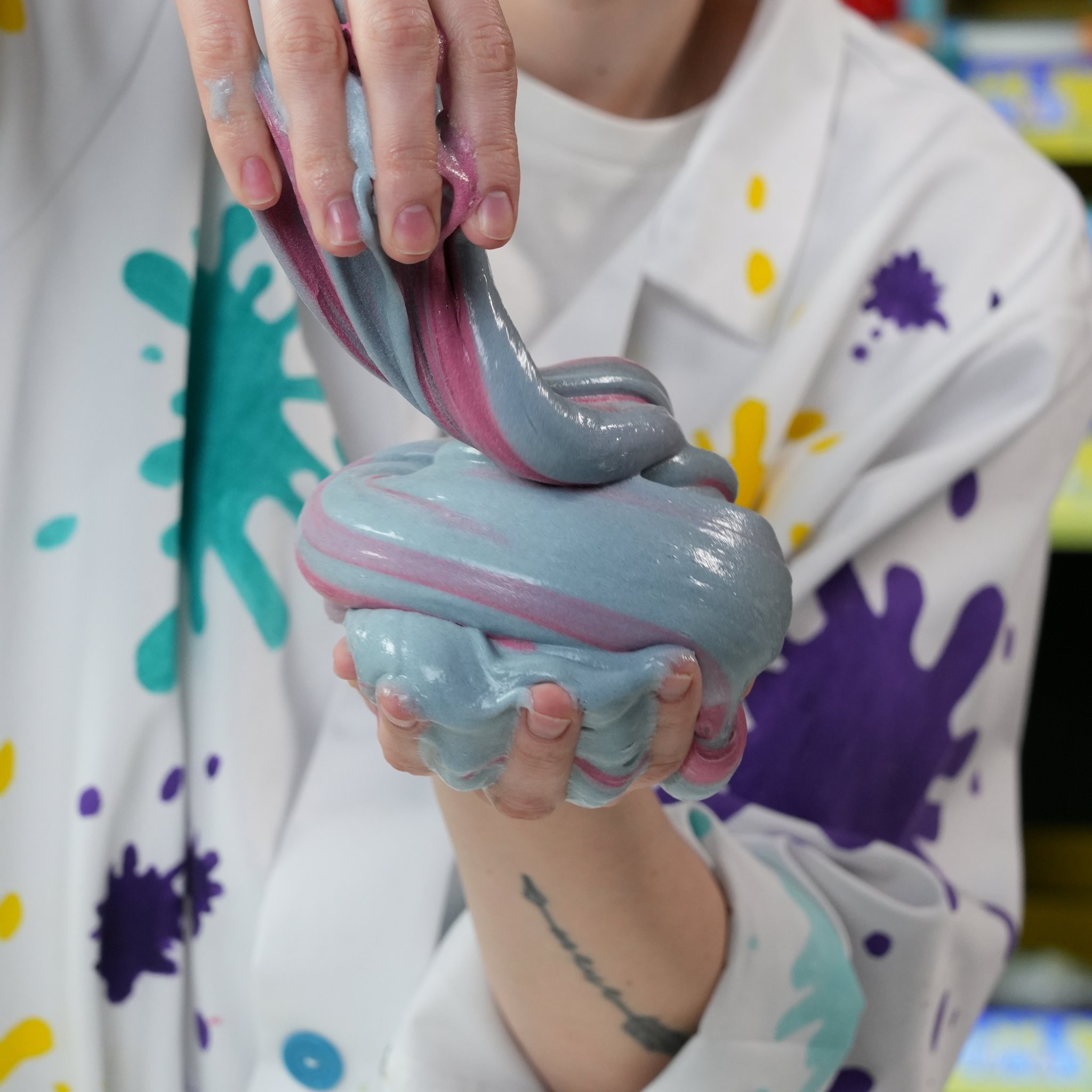 Rosa-blau marmorierter Fluffy Slime in der Hand