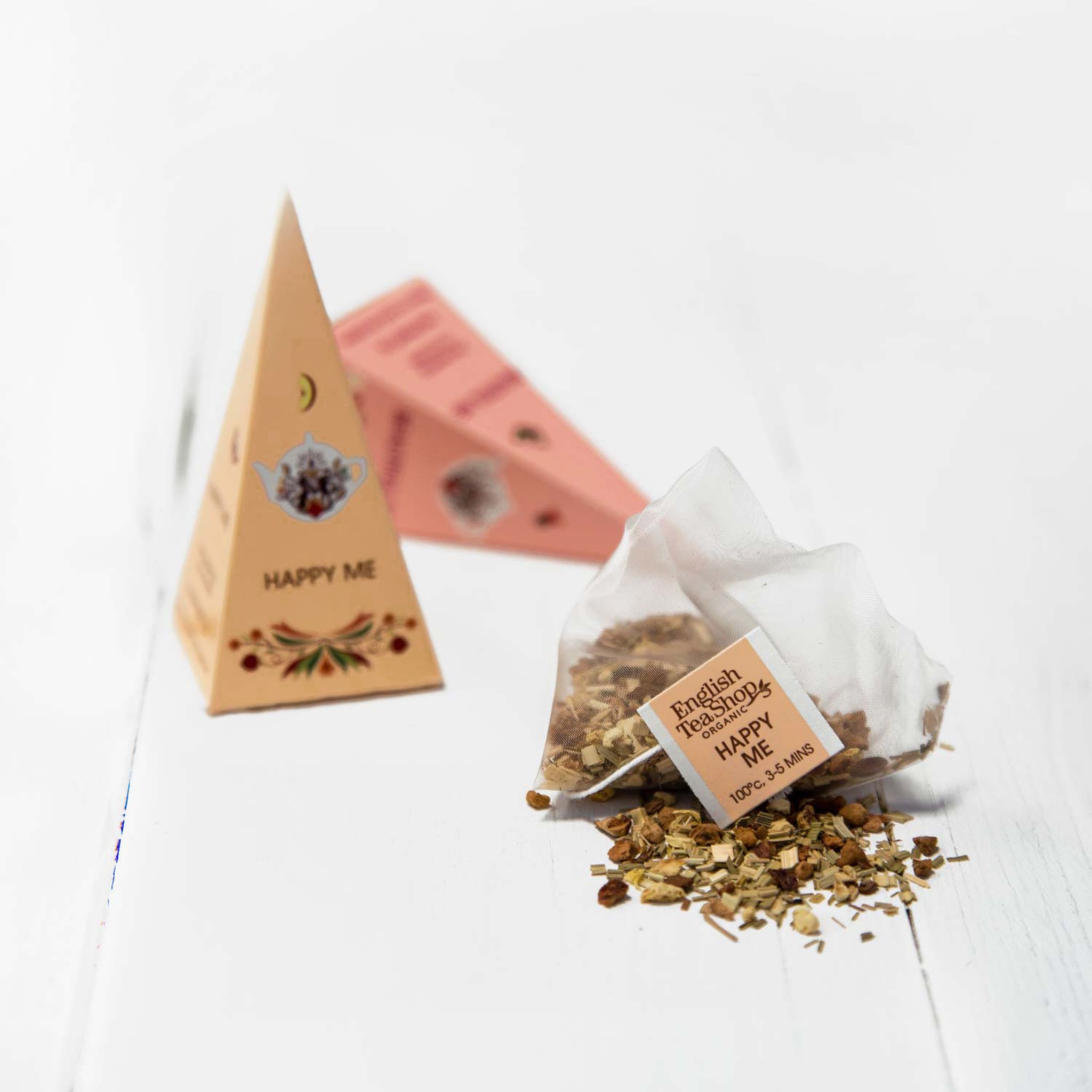Sachet pyramide Happy Me et thé en vrac devant deux pyramides du coffret bien-être