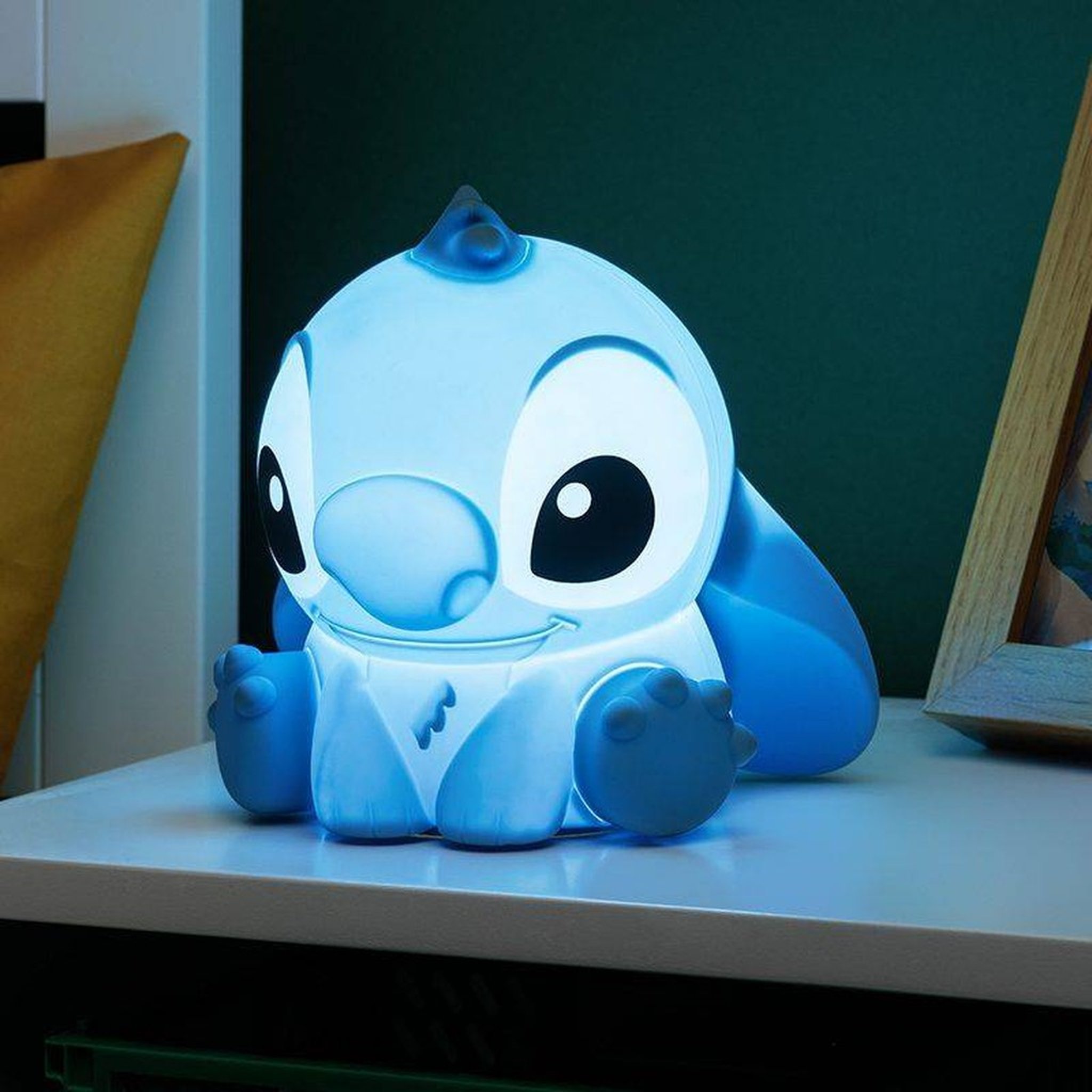 Stitch-Nachtlicht leuchtet blau auf einem Regalbrett