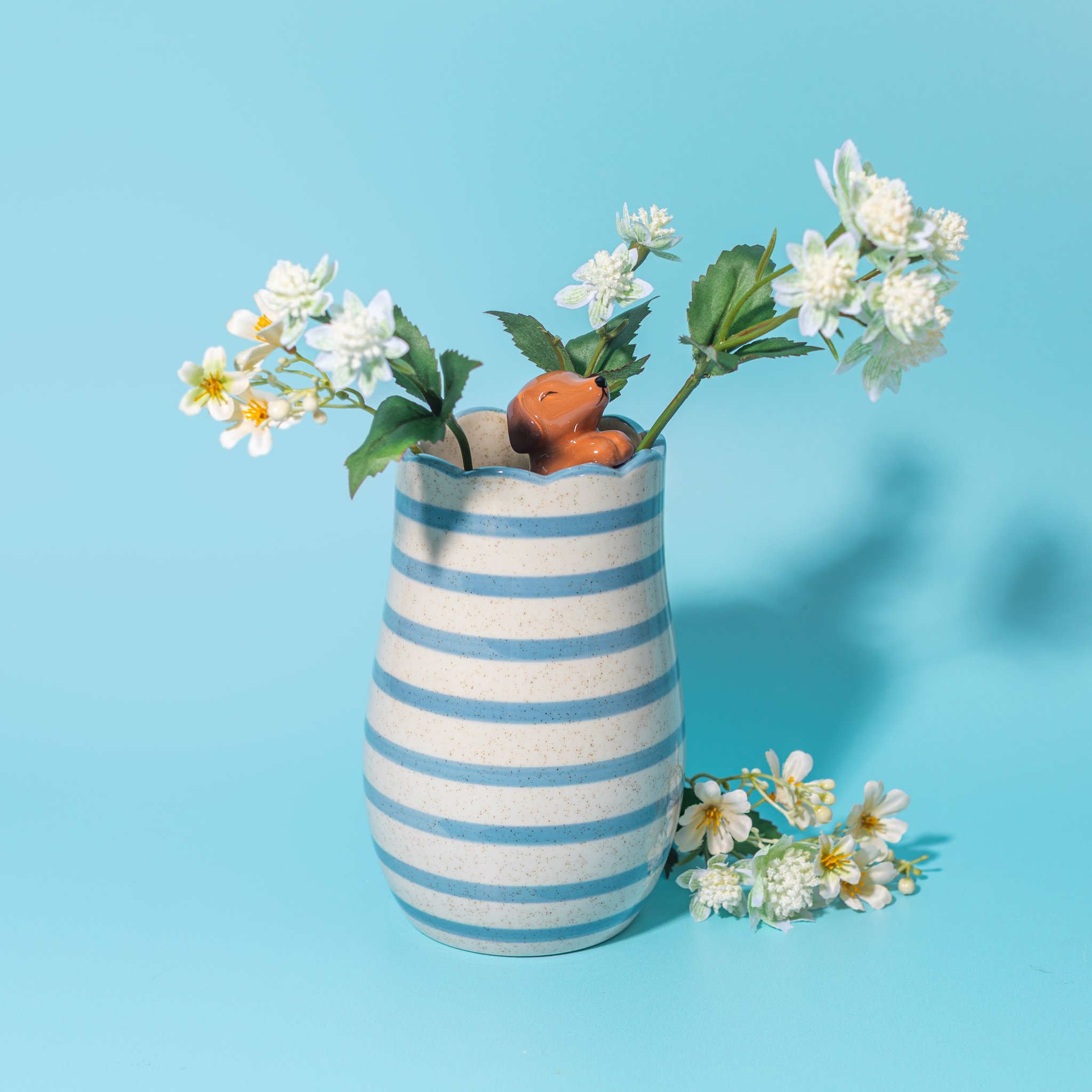 Dackel Vase blau-weiss gestreift mit Blumen auf blauem Hintergrund
